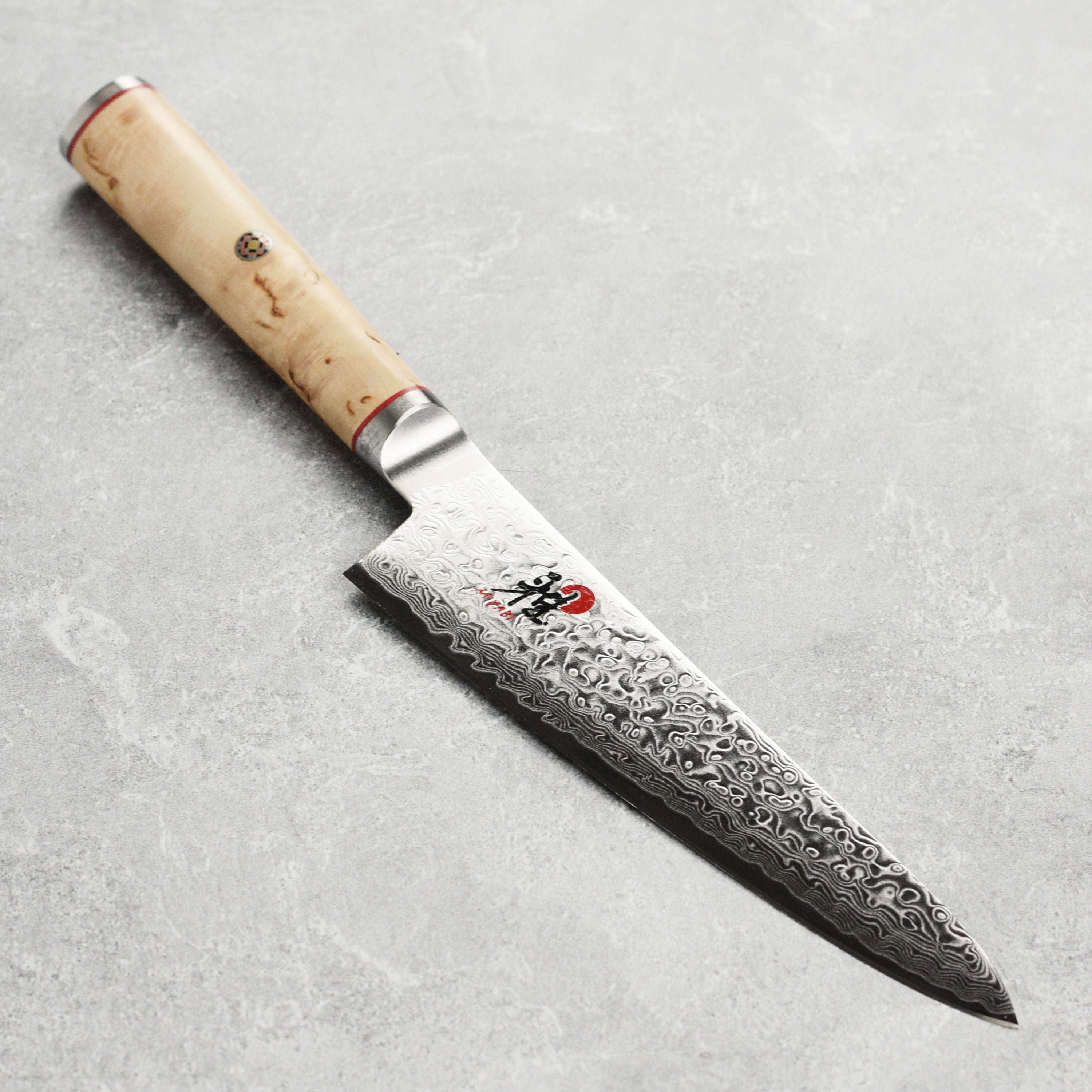Miyabi Birchwood Damascus prep knife blade close-up, highlighting the Damascus pattern and razor-sharp edge