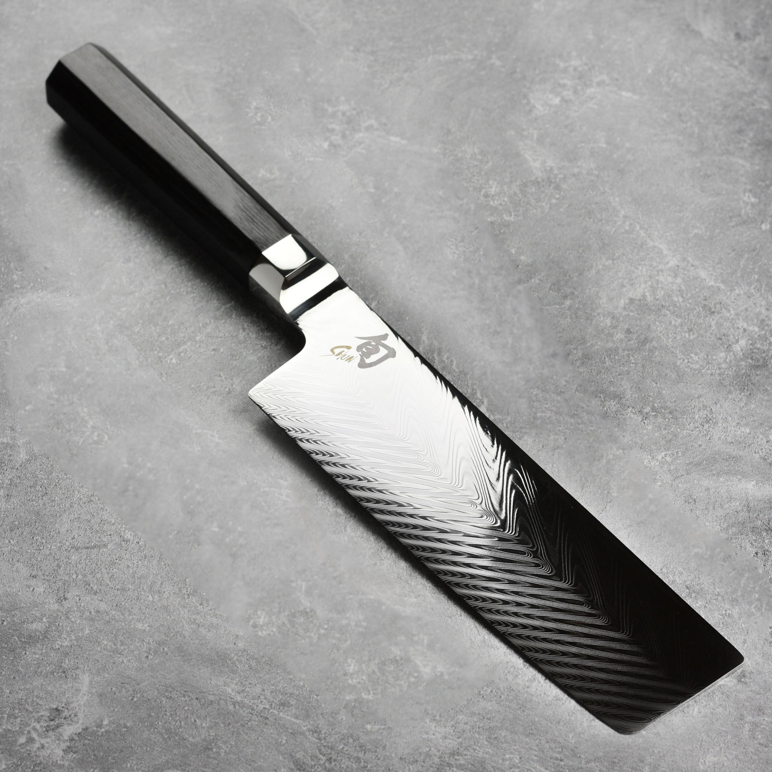 Shun Nakiri knife with layered steel blade and wooden handle for precise vegetable cutting