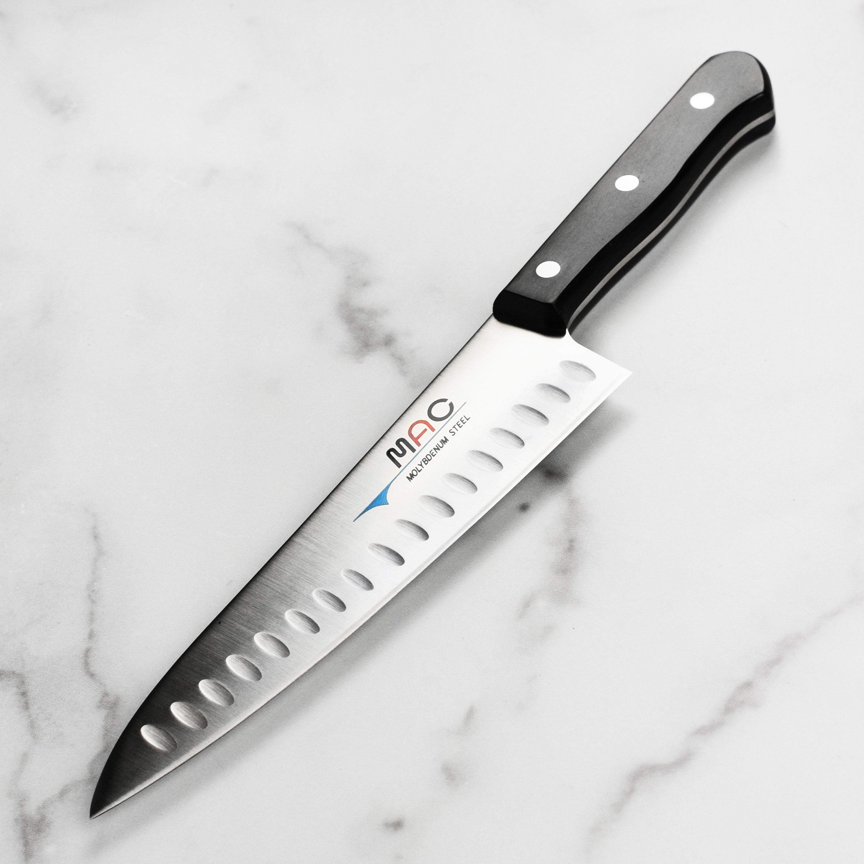 Close-up of MAC ProBalance 8 inch hollow edge chef knife on cutting board