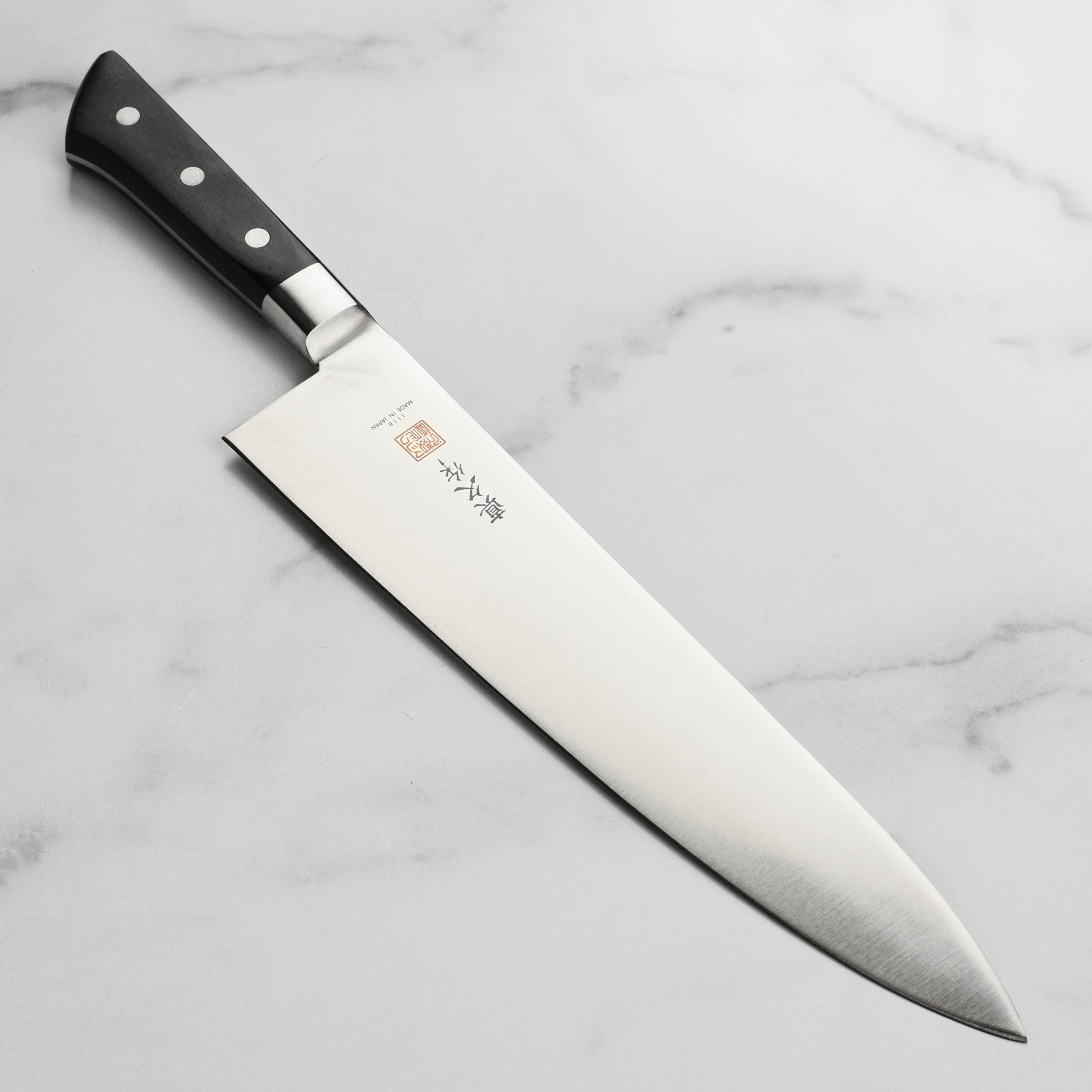 Side view of MAC 10.75-inch chef knife showcasing the high carbon blade and Pakkawood handle.