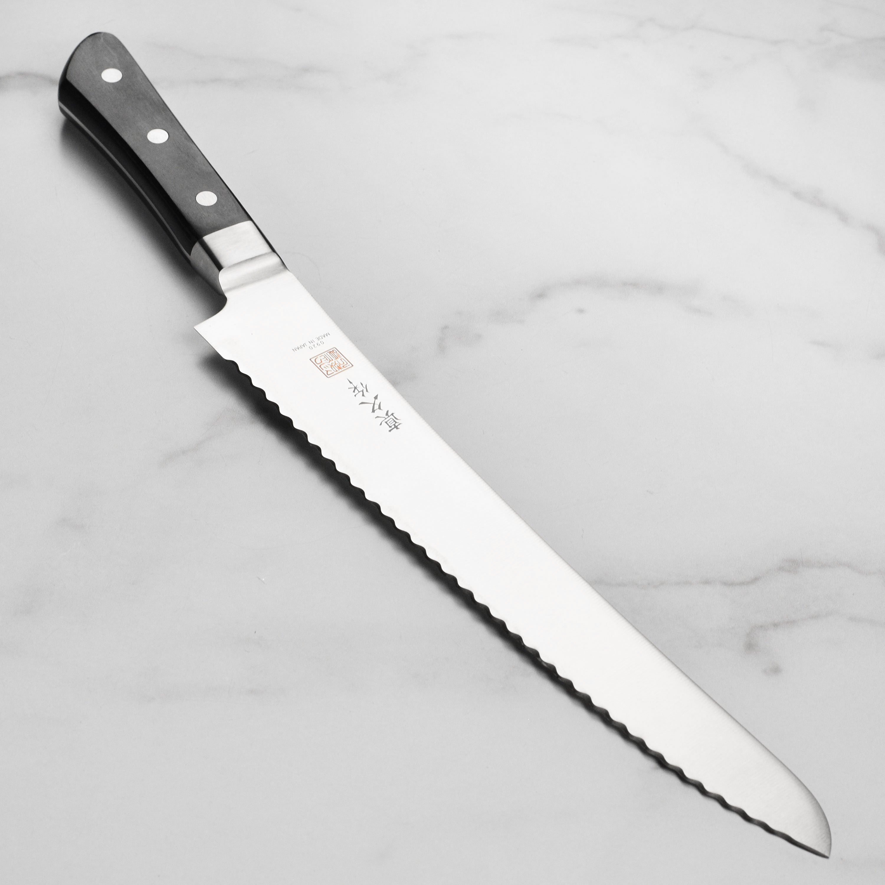 Premium Japanese bread knife with Pakkawood handle, showcasing its sleek design and sharp blade.