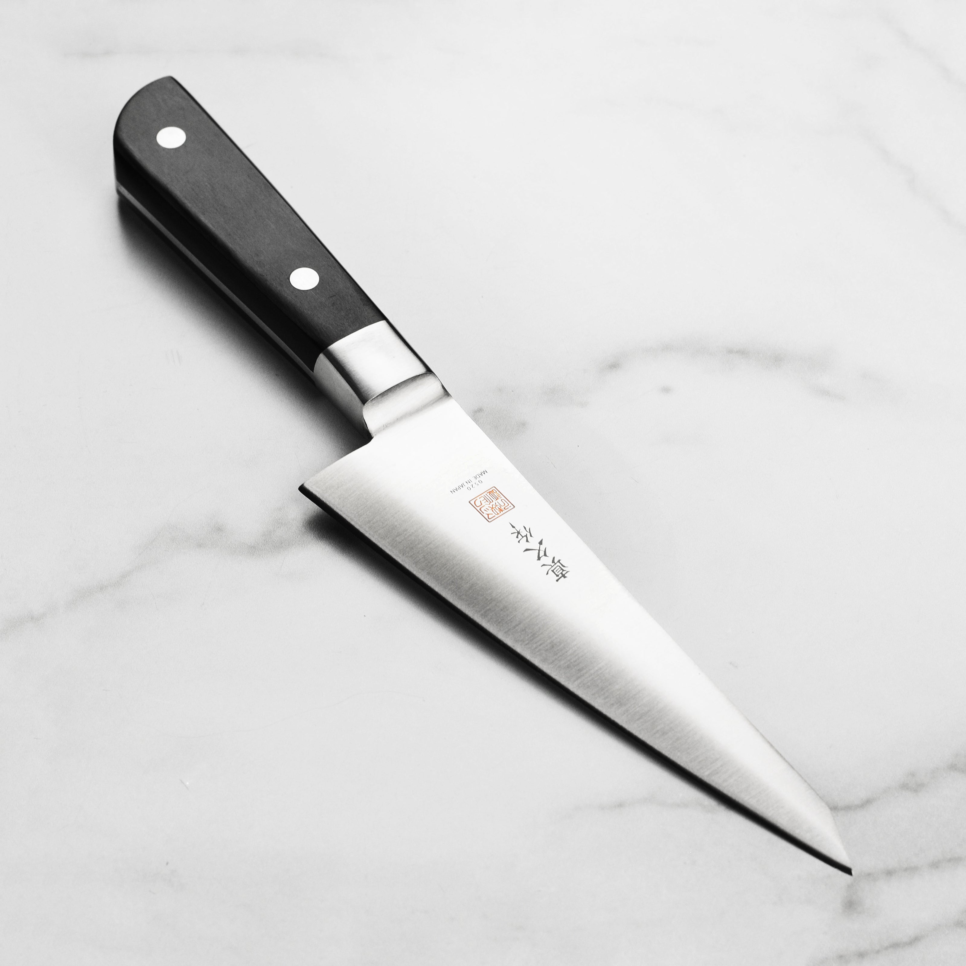 Premium Japanese 6-inch honesuki boning knife on a wooden cutting board showcasing its sharp blade and elegant handle.