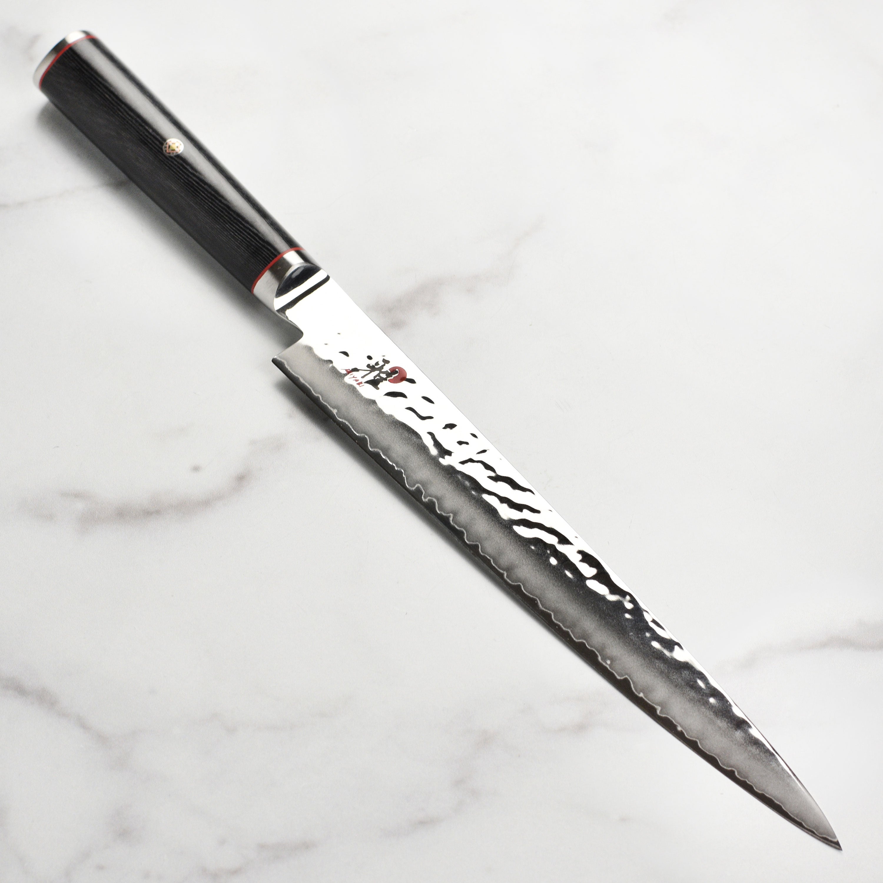 Miyabi Mizu SG2 9.5-inch Damascus slicing knife with textured finish and sharp blade for precise cutting