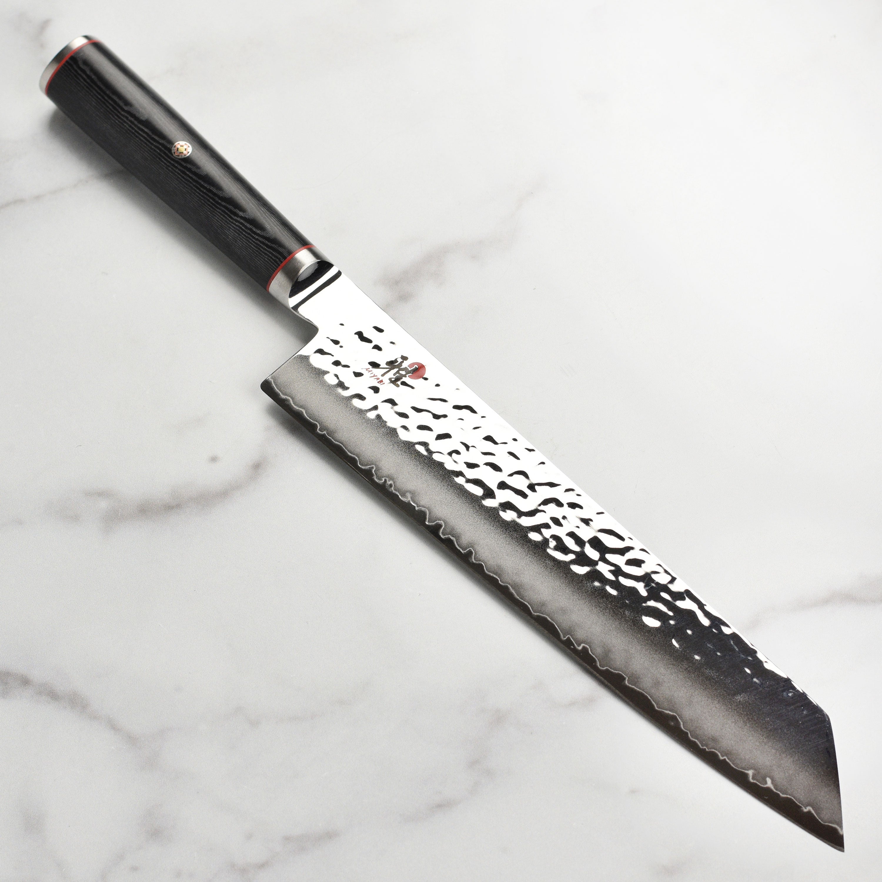 Close-up of the Miyabi Mizu SG2 9.5-Inch Kiritsuke knife highlighting the Damascus steel finish.