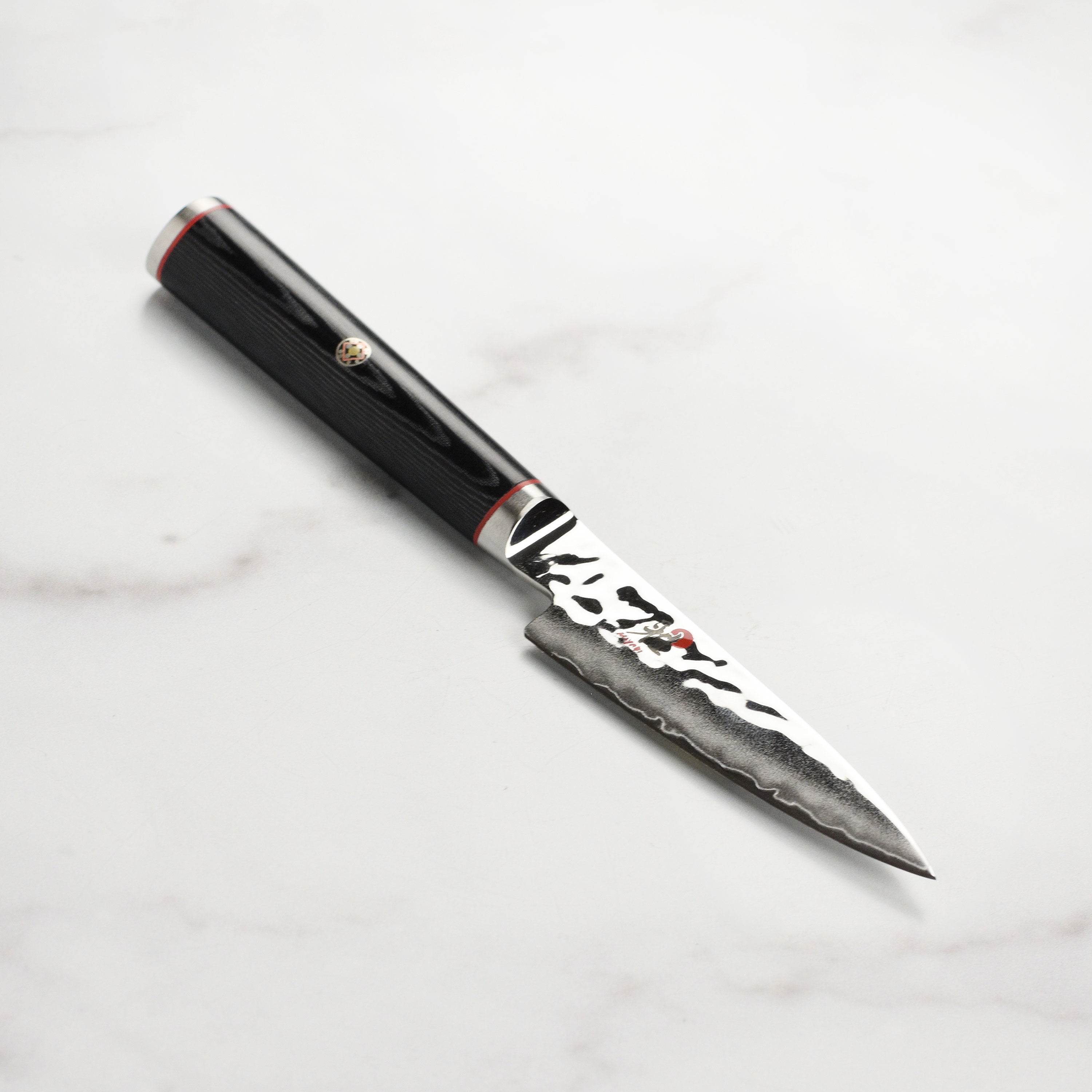 Close-up of the Miyabi SG2 paring knife blade with hammered Damascus finish