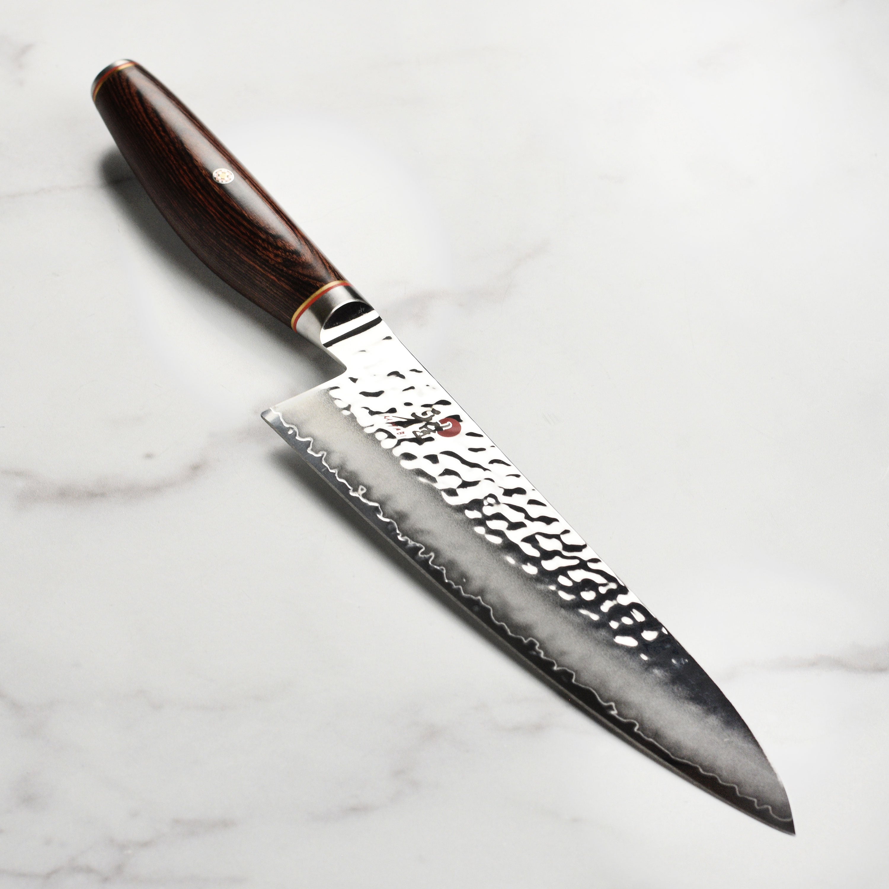 Close-up angle of Miyabi knife showing Damascus texture and handle detailing