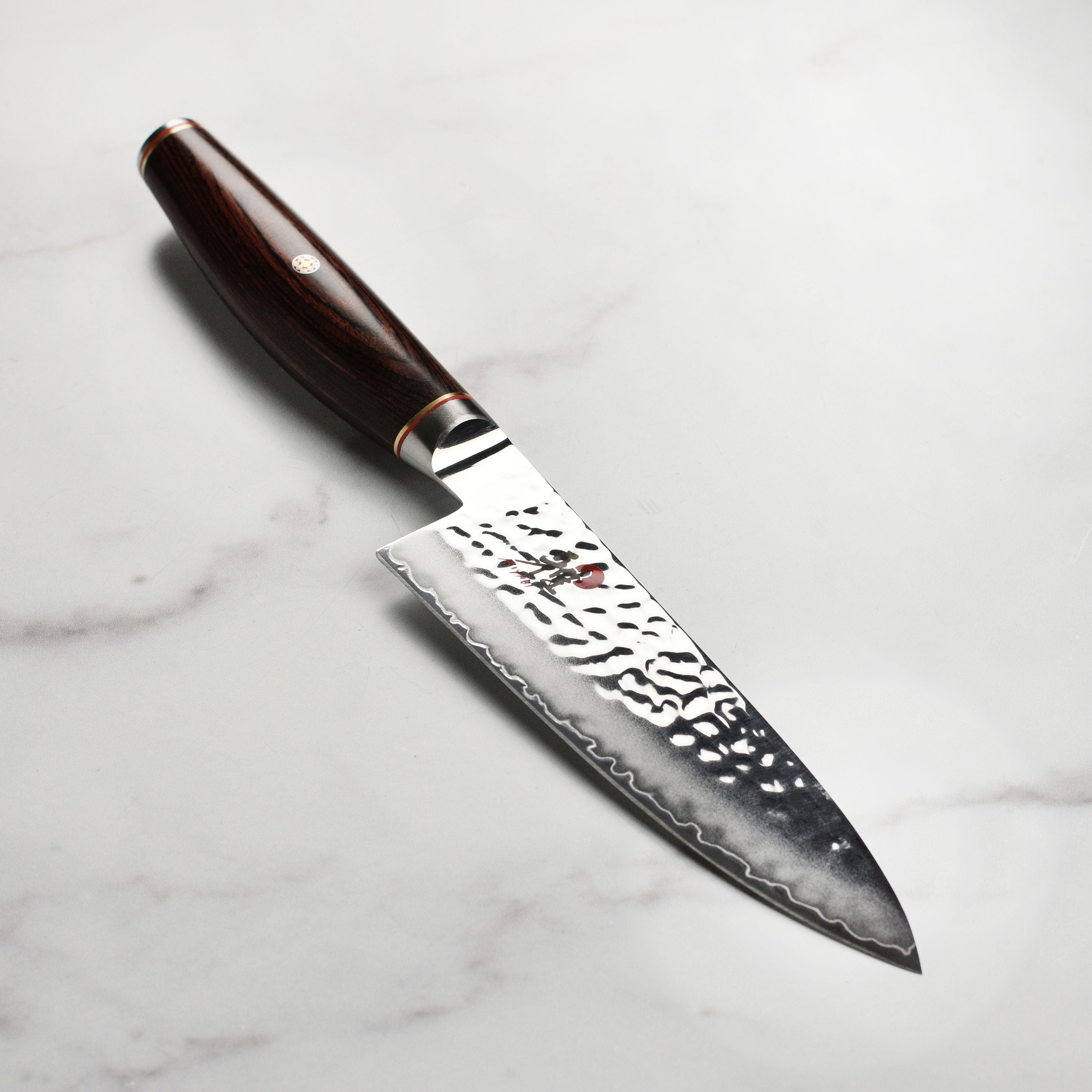 Close-up of the Miyabi Artisan SG2 chef's knife showcasing the Damascus blade and handle.