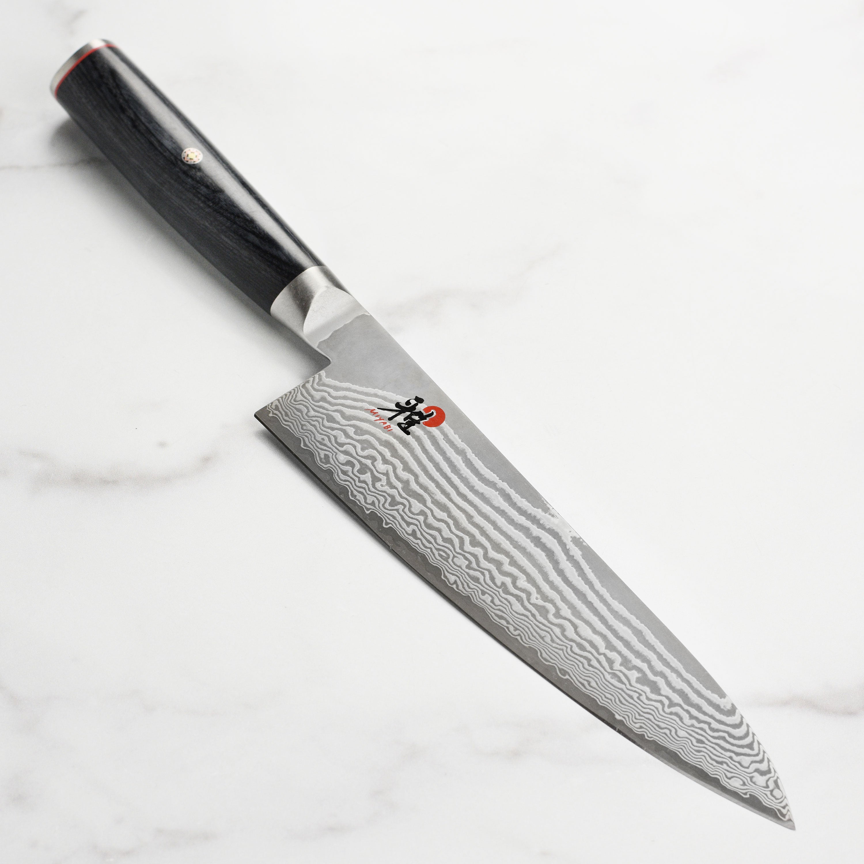 Close-up view of the Miyabi Kaizen II Damascus chef's knife showcasing its intricate blade design.