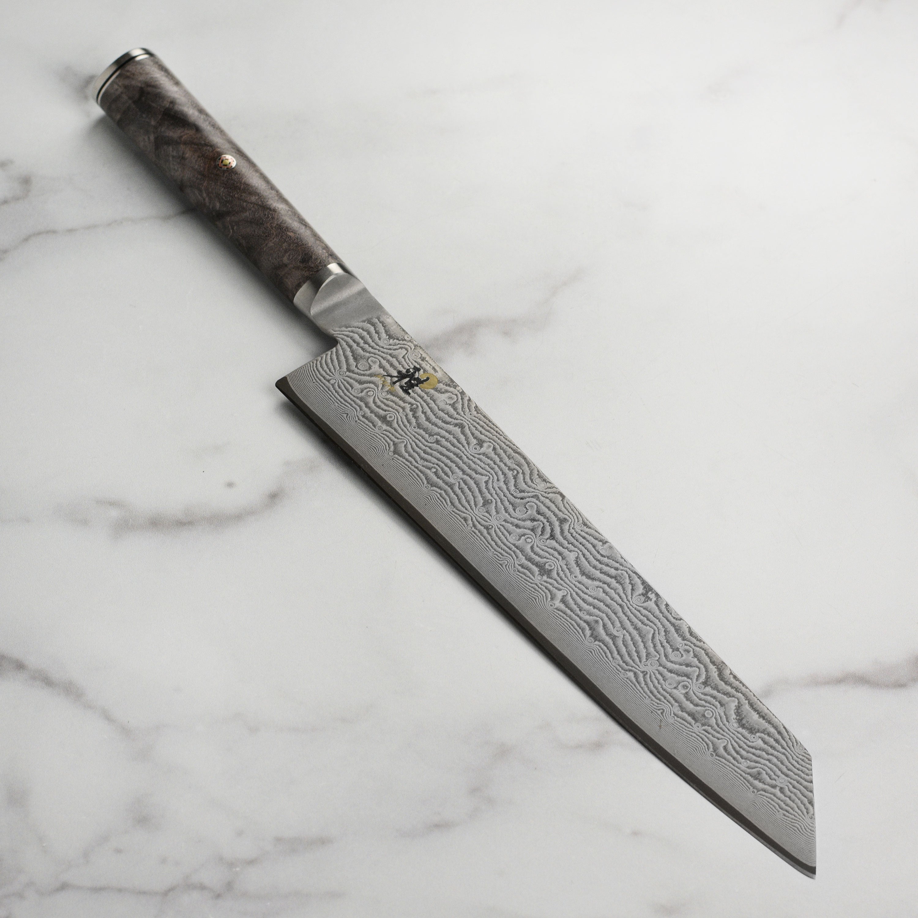 Miyabi Black Kiritsuke Knife from above, highlighting the Damascus blade and D-shaped handle.