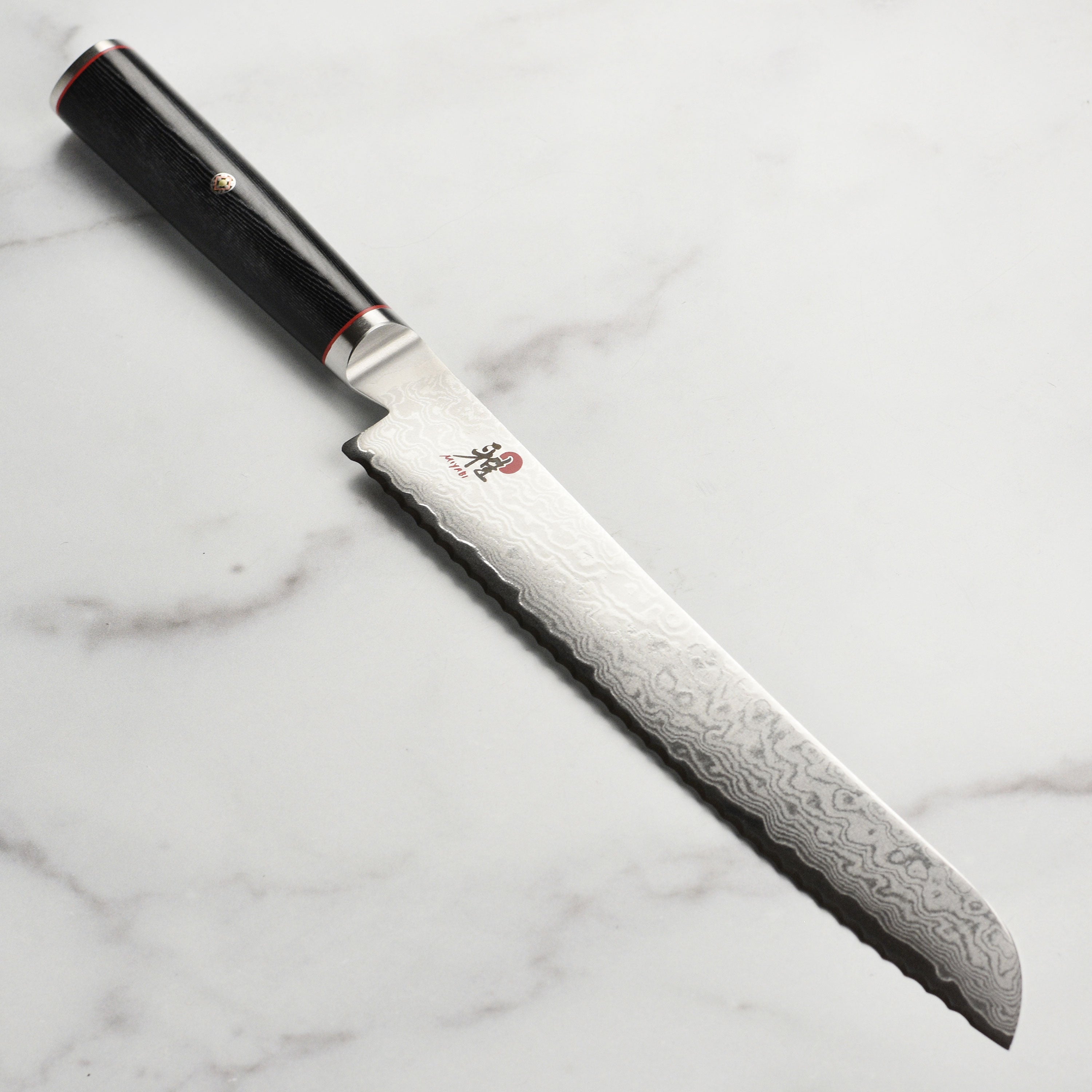 Close-up of the 9-inch Damascus bread knife highlighting its VG10 steel blade and unique Damascus pattern.