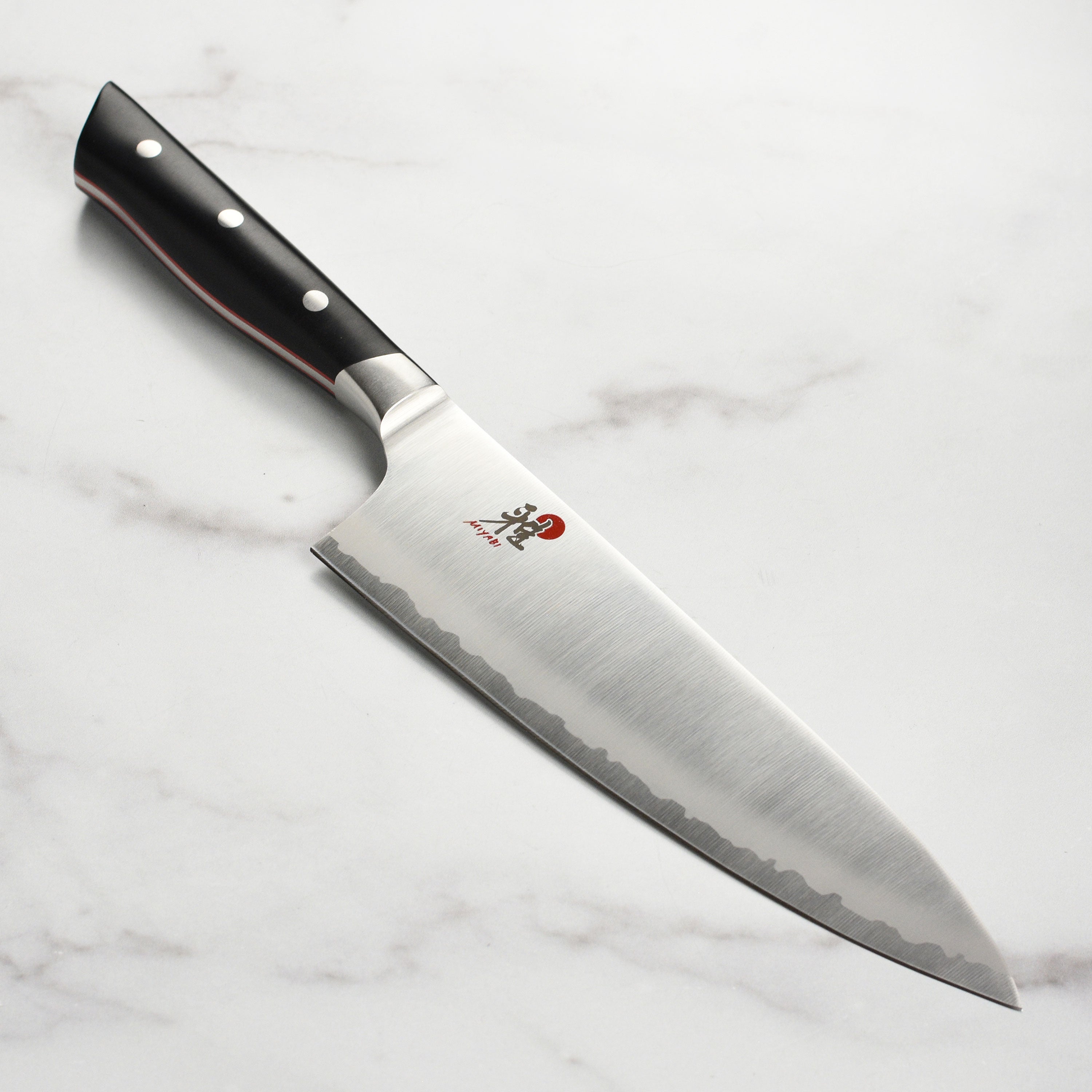 Miyabi Evolution 8 inch Japanese chef's knife with ergonomic handle on bamboo cutting board