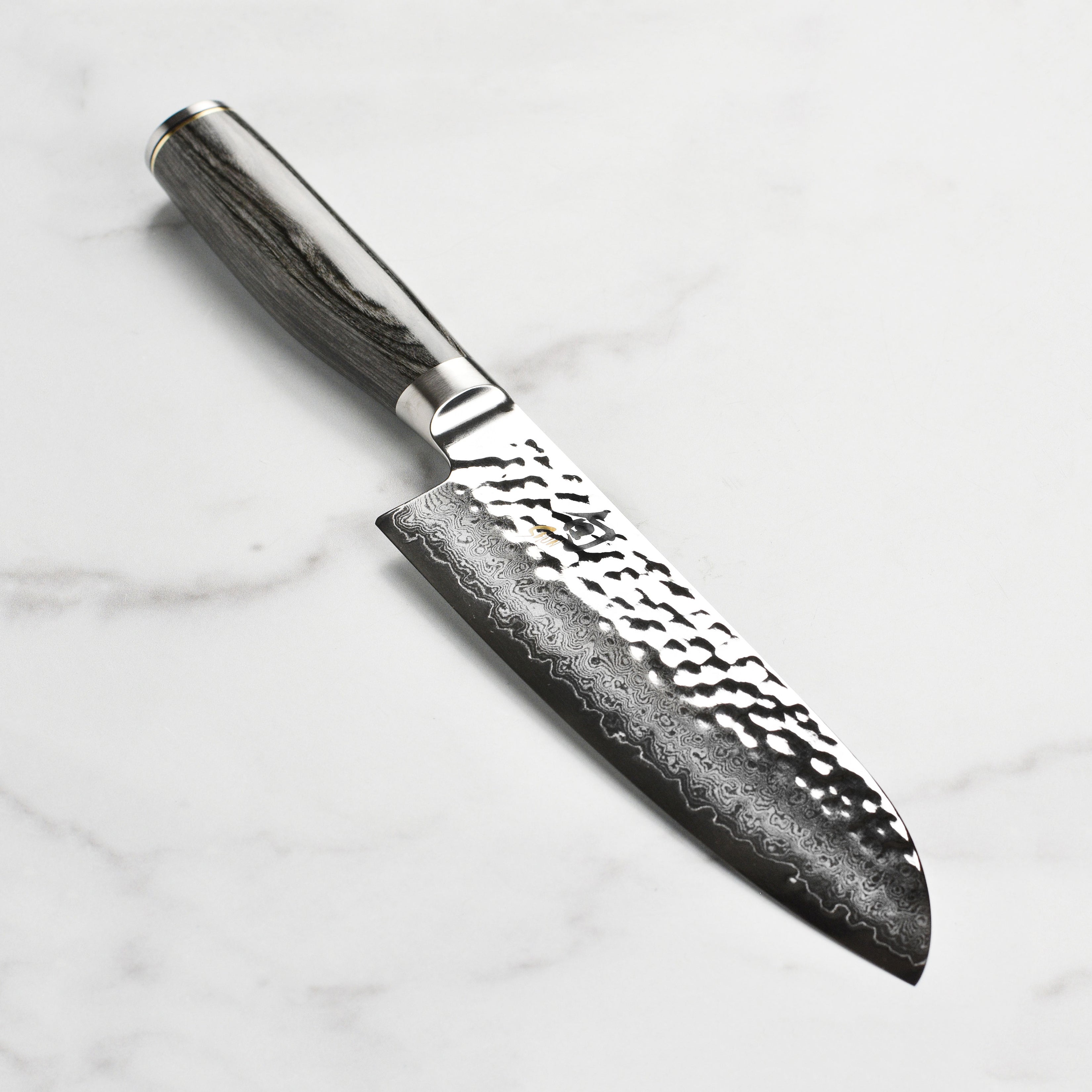 Close-up of the Shun Premier Santoku knife blade highlighting the Damascus steel pattern and hand-sharpened edge.