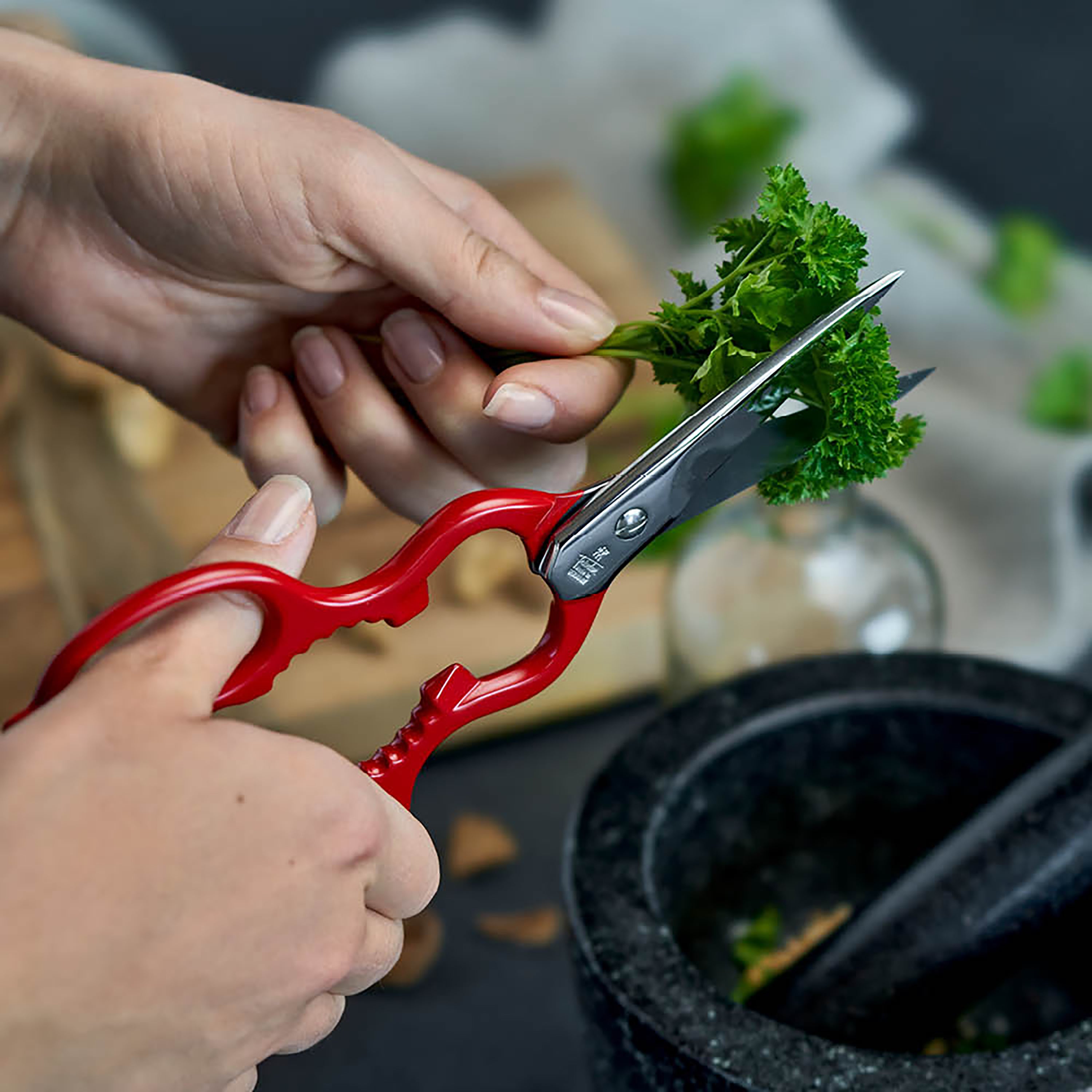 Kitchen shears in action, cutting through fresh herbs with ease.