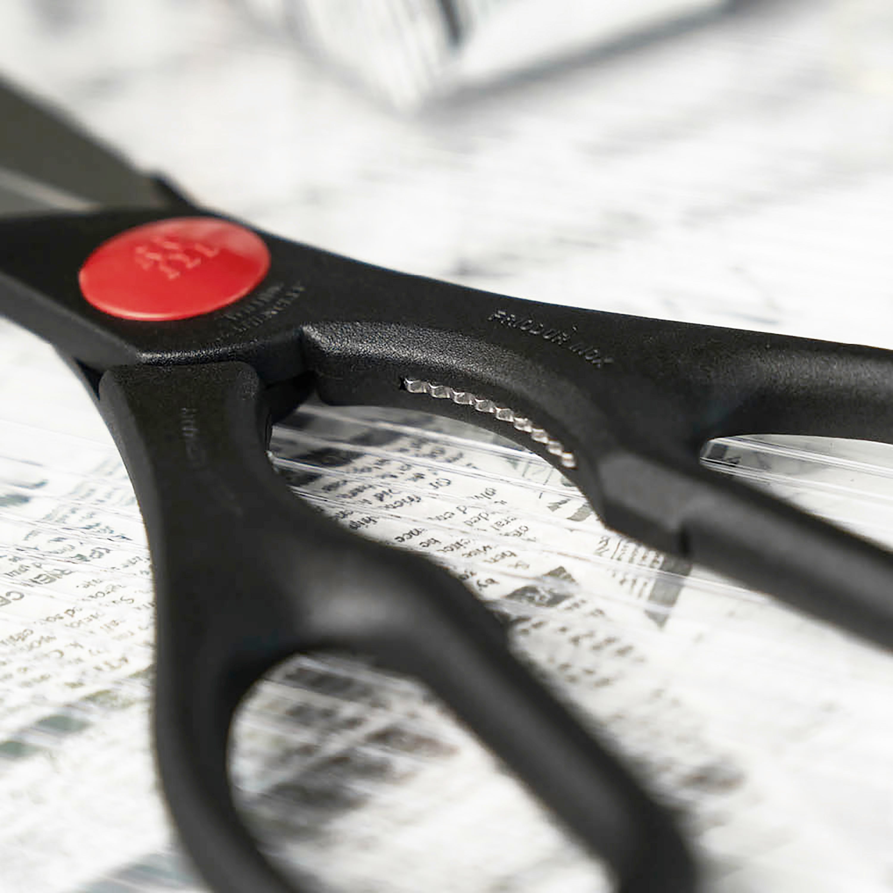 Angled view of heavy duty stainless steel kitchen scissors with micro-serrated blades