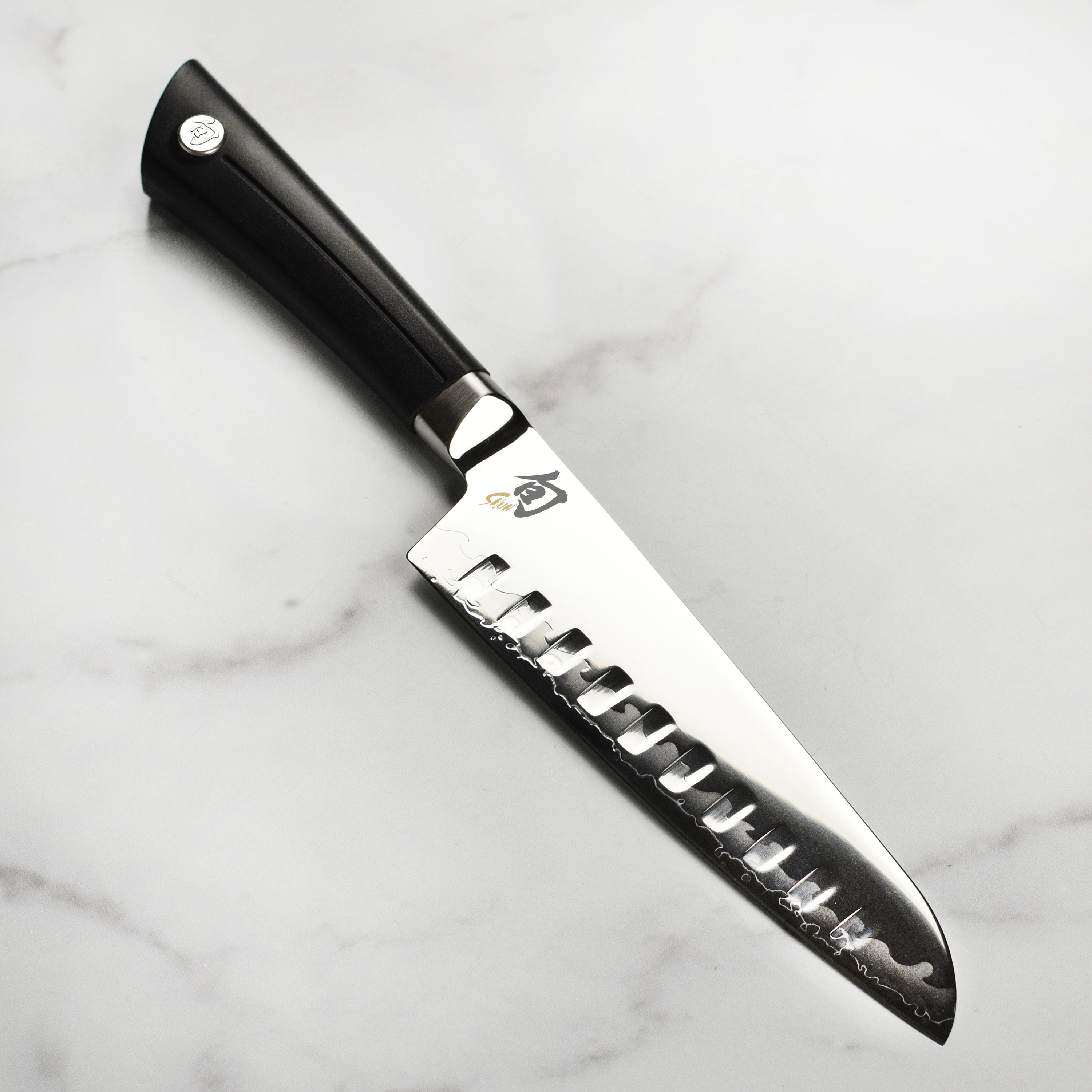 Shun Sora 7-inch hollow edge Santoku knife showcasing its layered VG10 steel blade