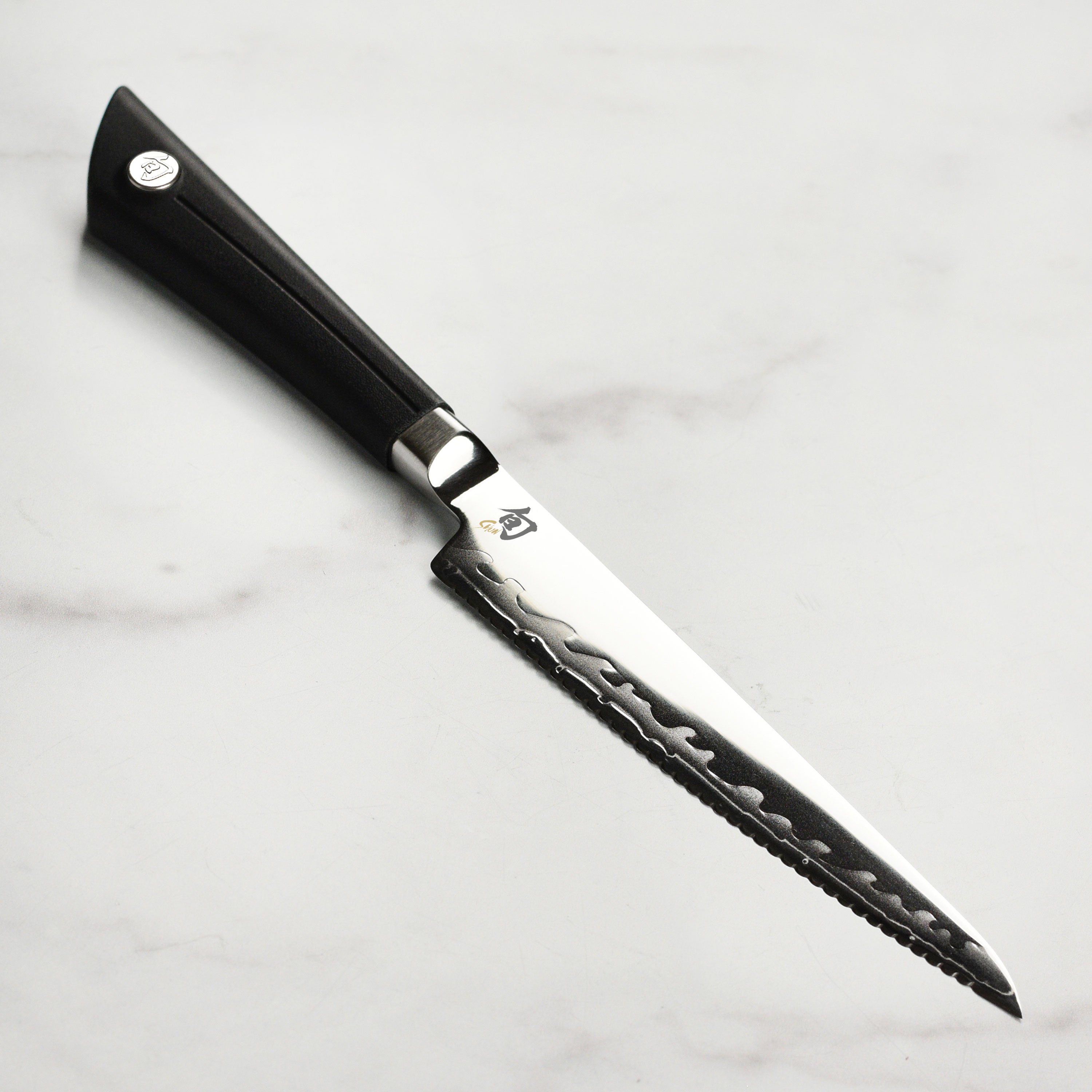 Close-up of the Shun Sora 5.5-inch utility knife highlighting its serrated blade and craftsmanship.