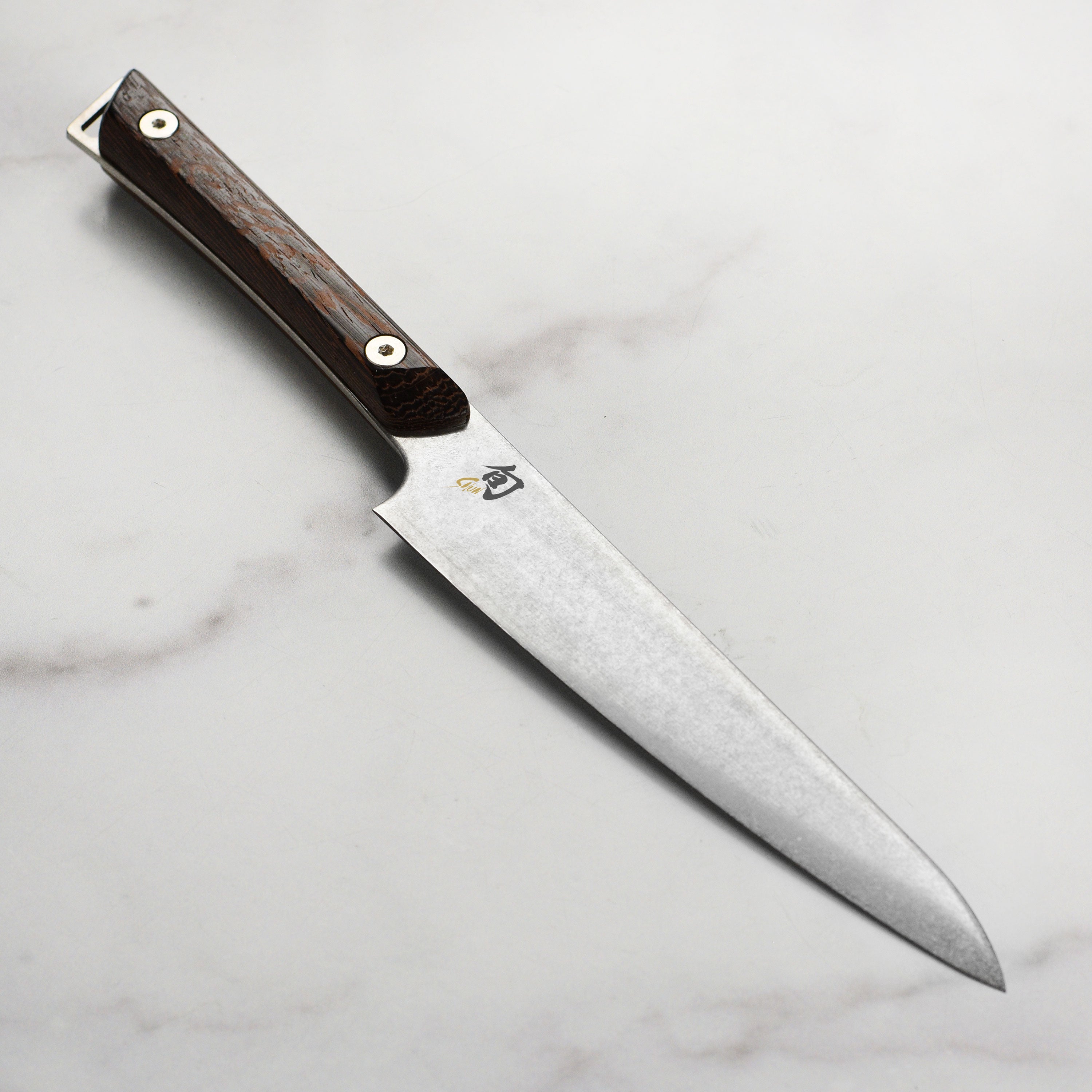 Close-up of the Shun Kanso utility knife blade highlighting its sharp edge and Heritage finish.