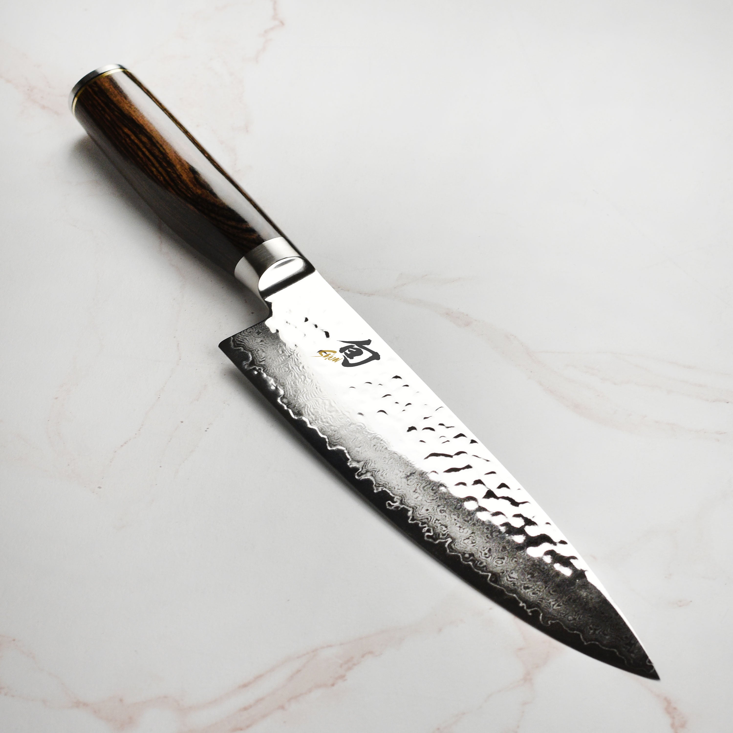 Sleek Shun Premier 8-Inch Chef's Knife with a Damascus finish, ideal for slicing vegetables.