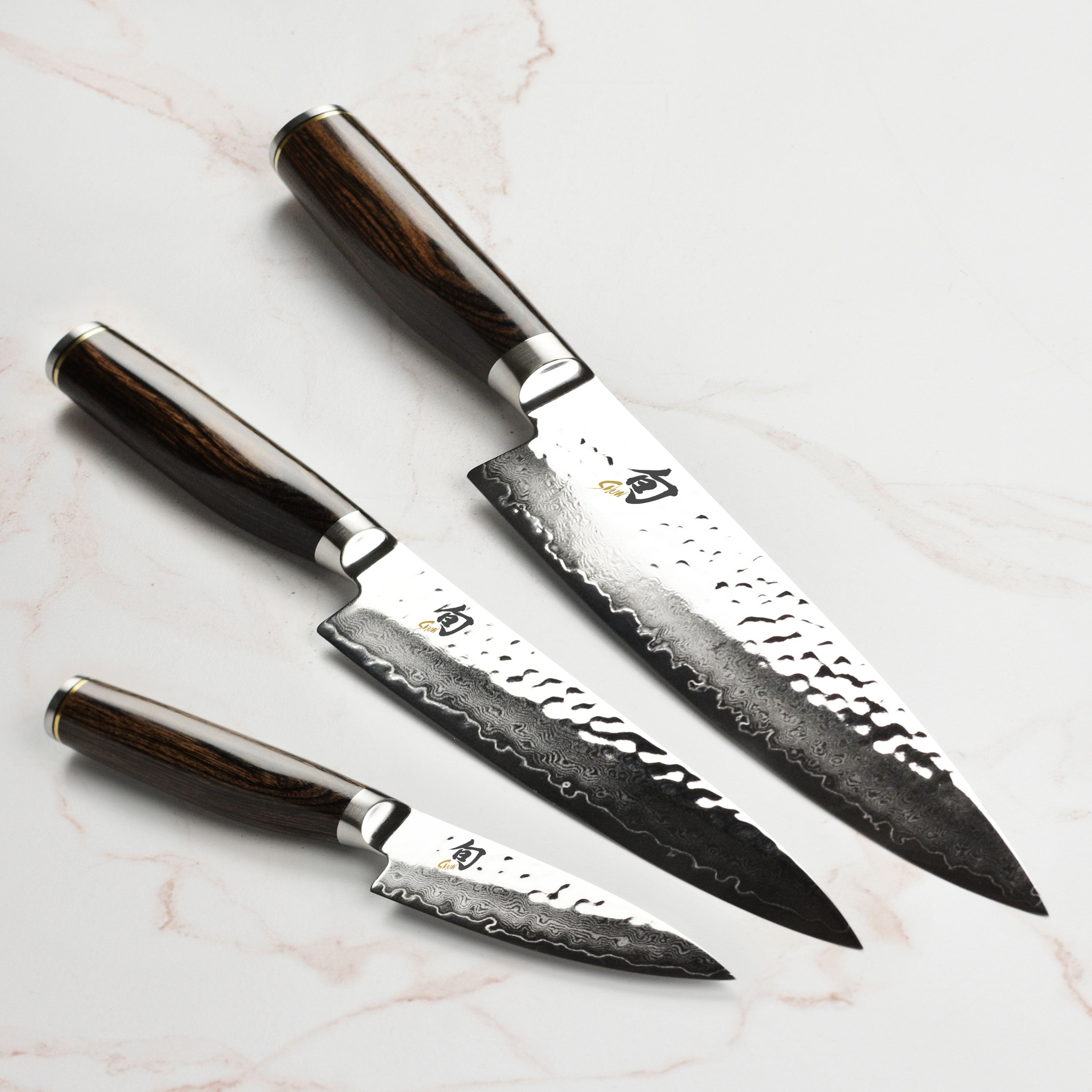 Close-up of Shun Premier Japanese chef knife highlighting Damascus steel layers and hammered finish