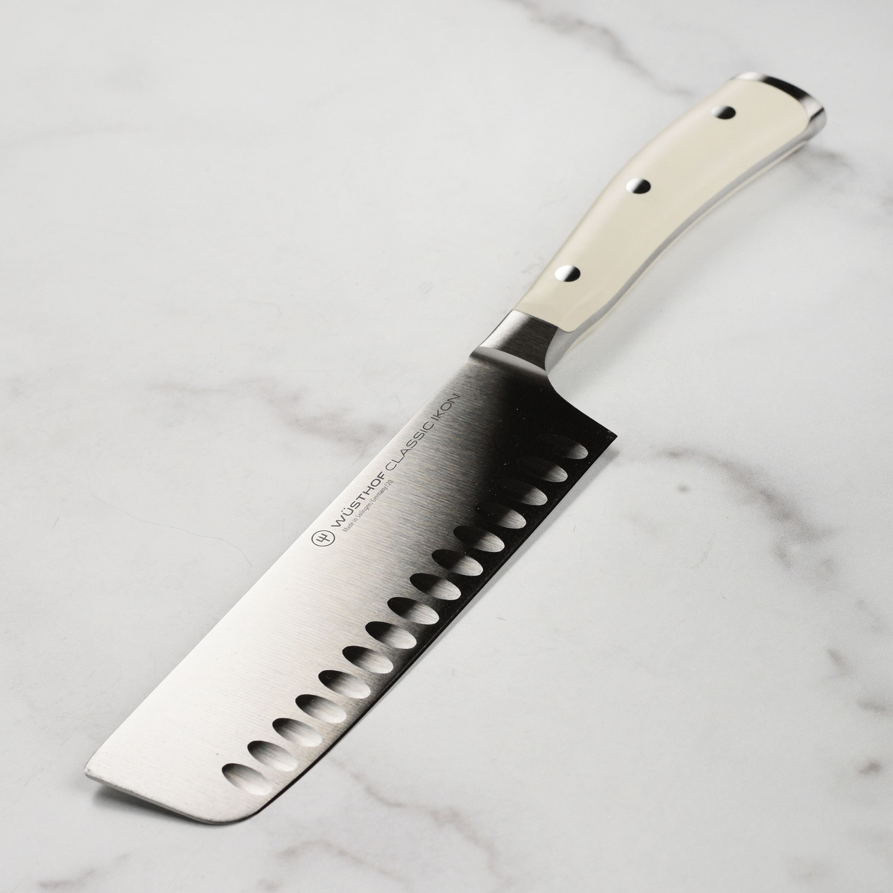 Angled top-down view of the Wusthof Nakiri knife highlighting its precision-forged blade and creme handle