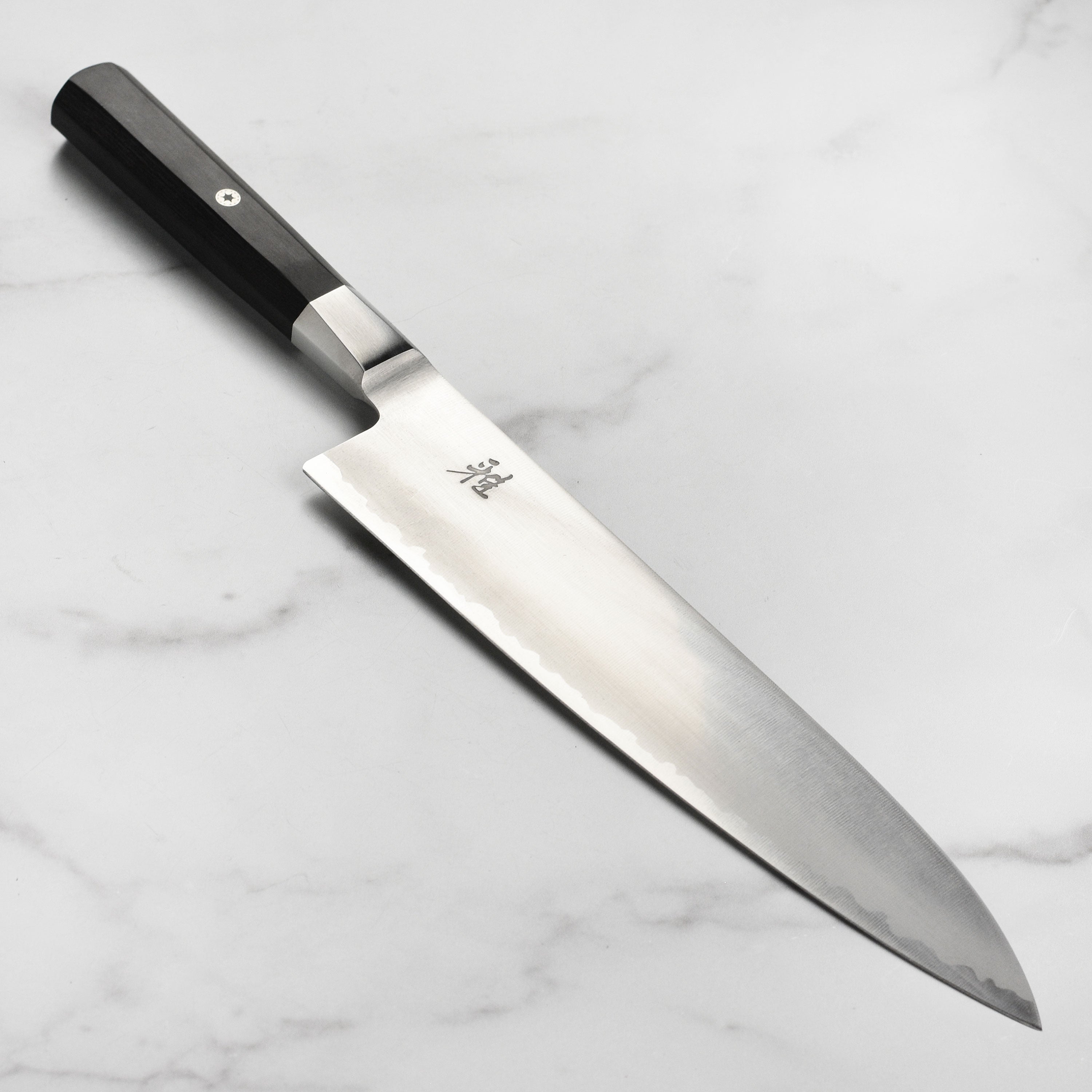 Close-up of Miyabi Koh 9.5-inch Japanese chef's knife blade highlighting the sharp edge and craftsmanship