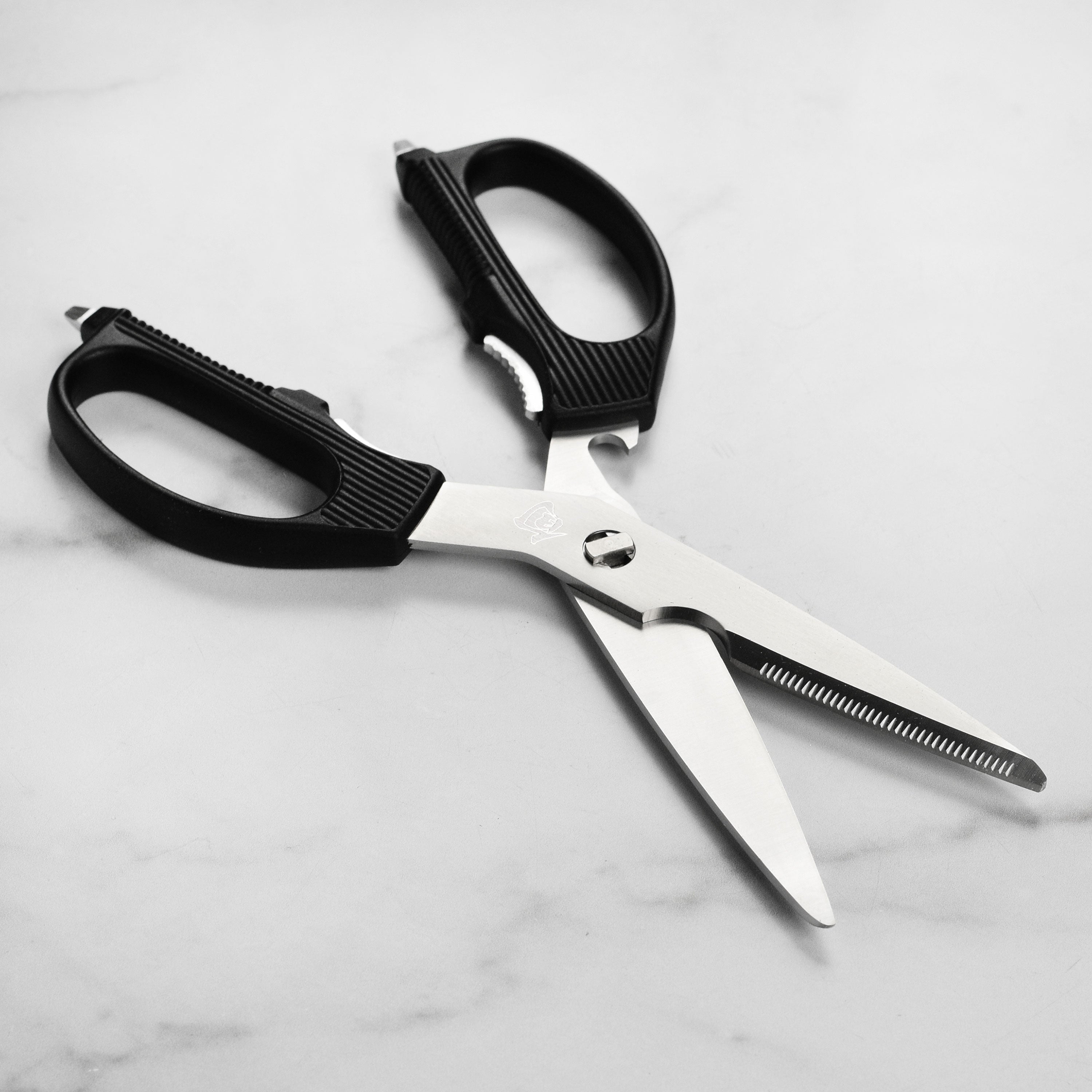 Close-up of Shun stainless steel shears with bone notch on cutting board
