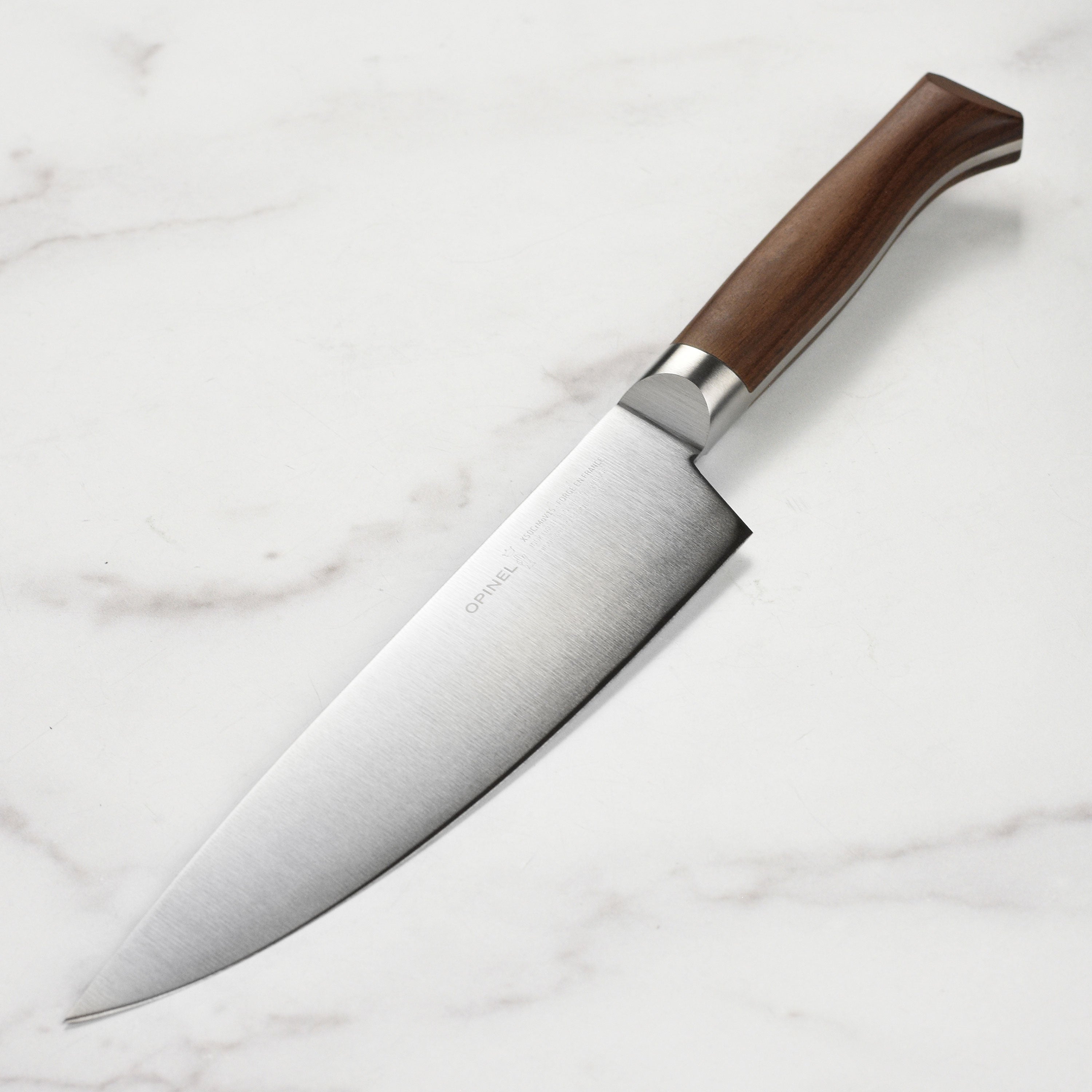 Close-up of the Opinel forged cooking knife showing its ergonomic beech handle and V-grip