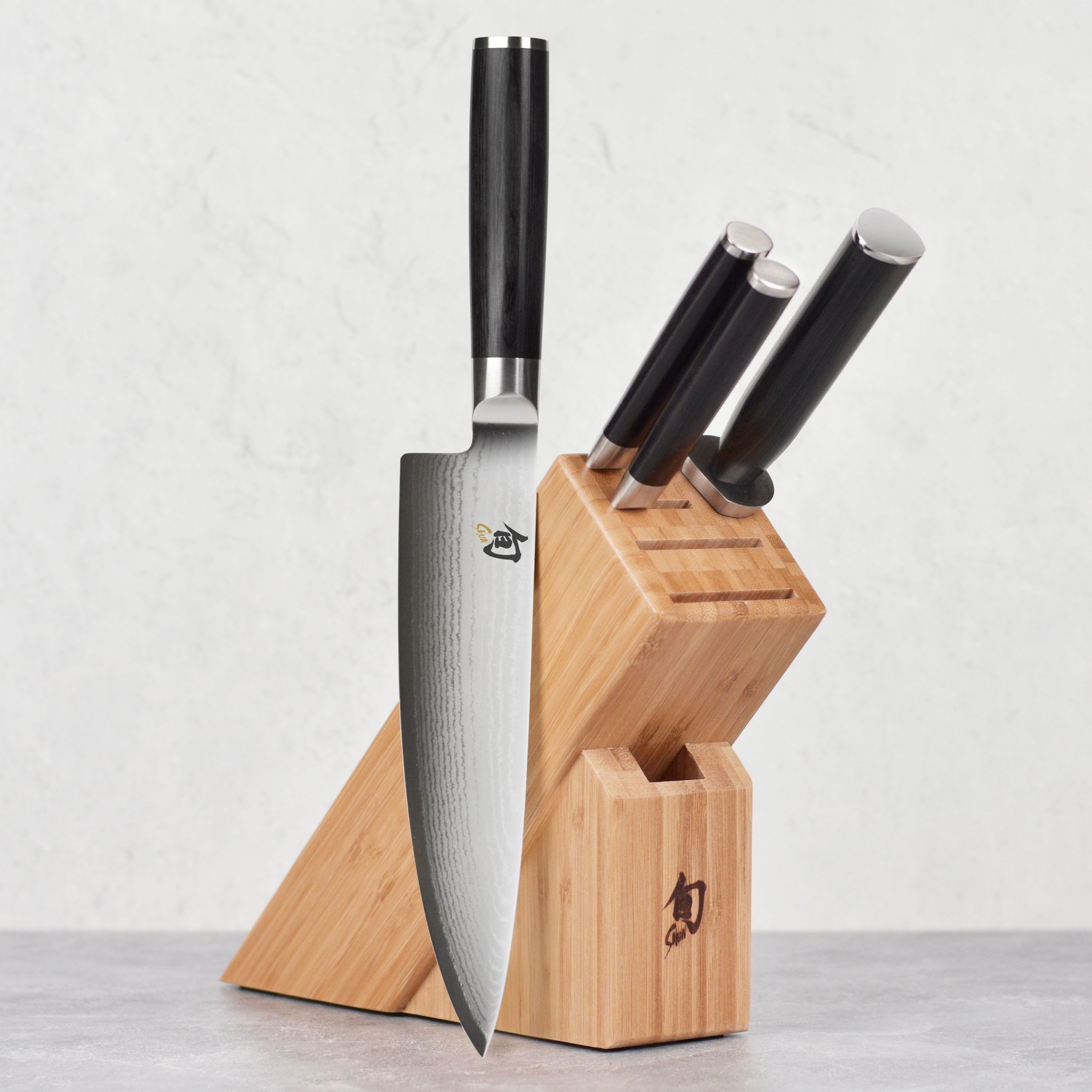Close-up of the Shun Classic 5-Piece Knife Set showcasing the Damascus blade patterns and elegant PakkaWood handles.