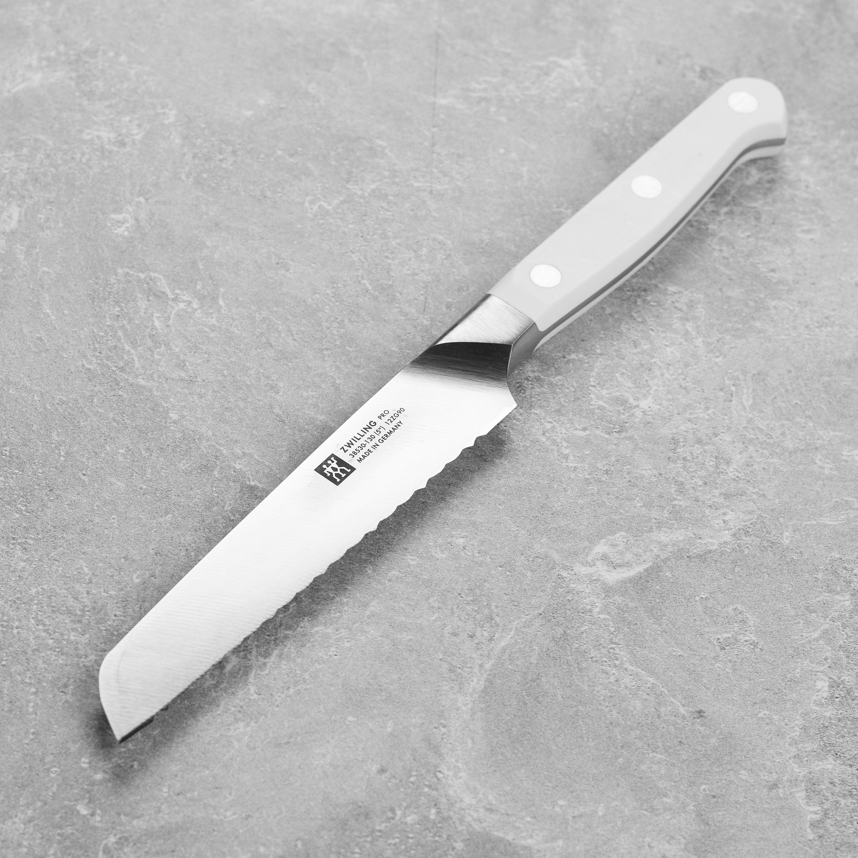 Close-up of the Zwilling Pro 5-inch serrated utility knife showcasing its sharp blade and ergonomic handle.