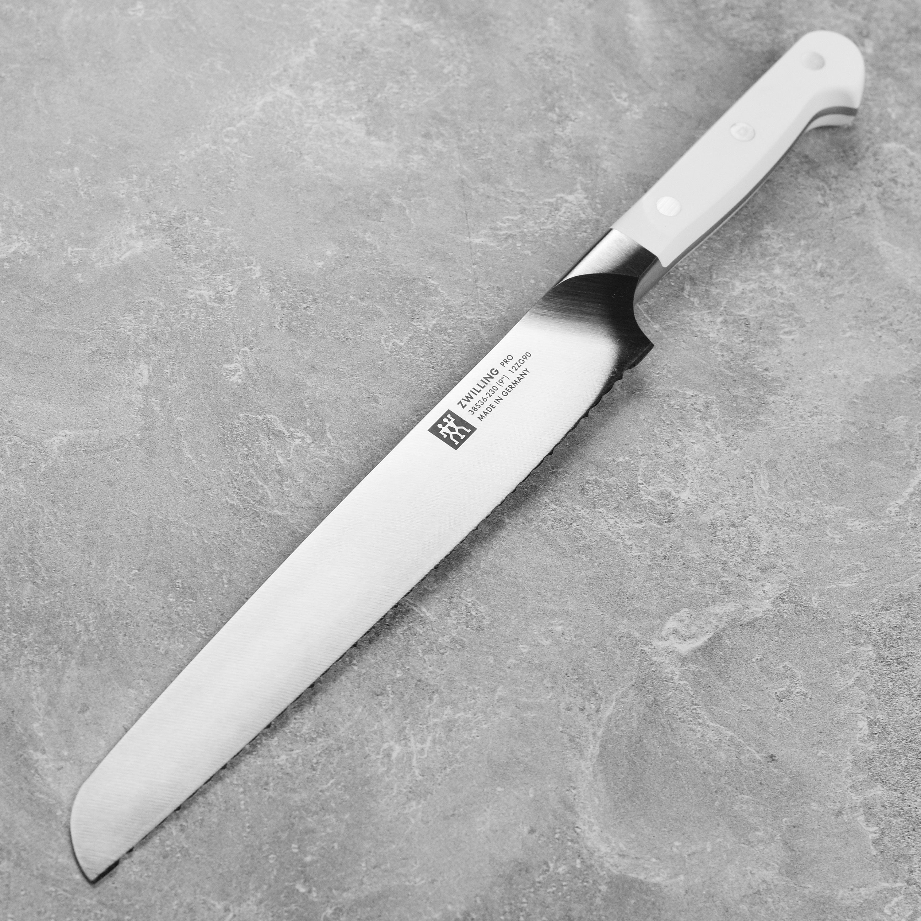 Zwilling Pro Le Blanc 9-inch serrated bread knife slicing bread in a modern kitchen