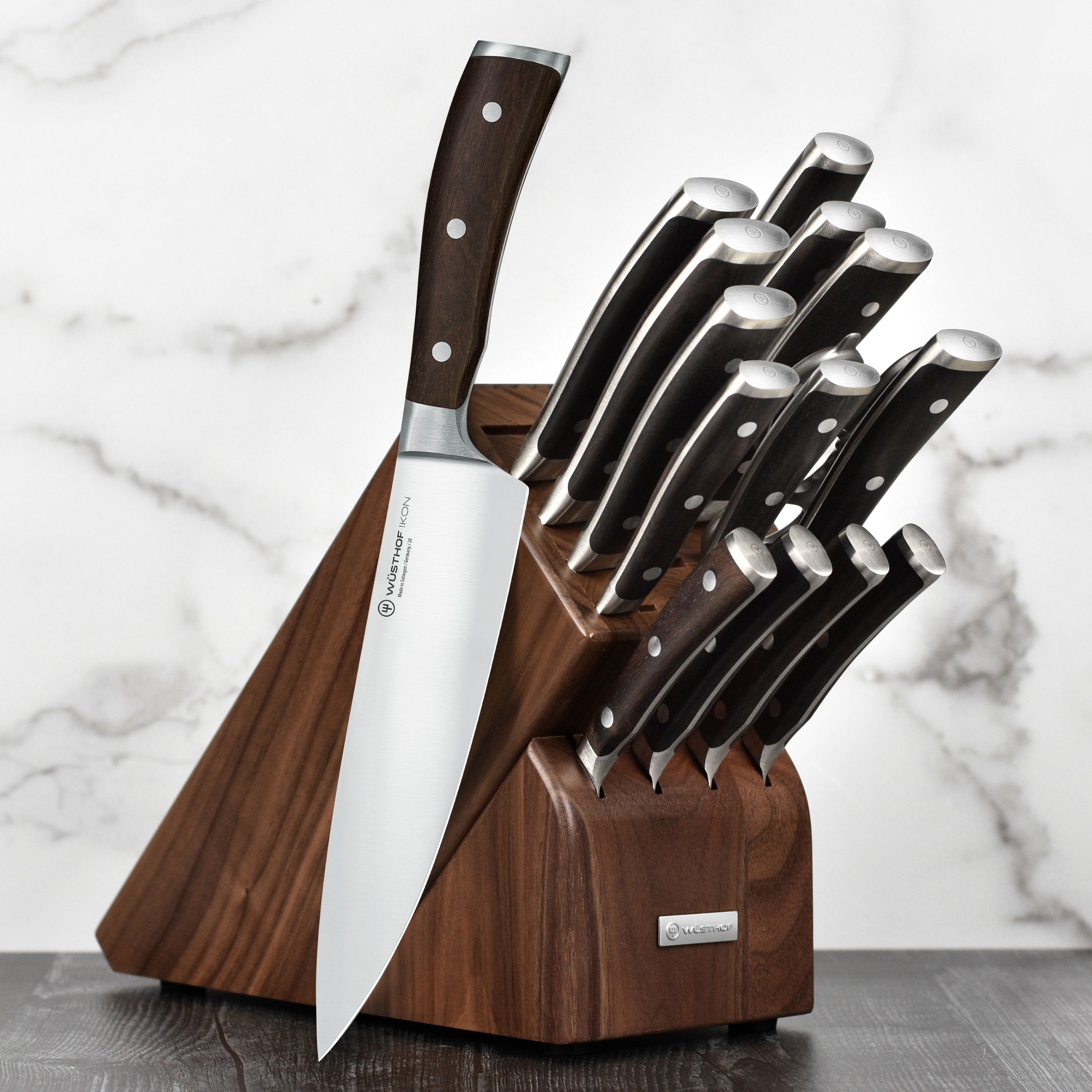 Close-up of Wusthof Ikon Blackwood chef knives in walnut knife block