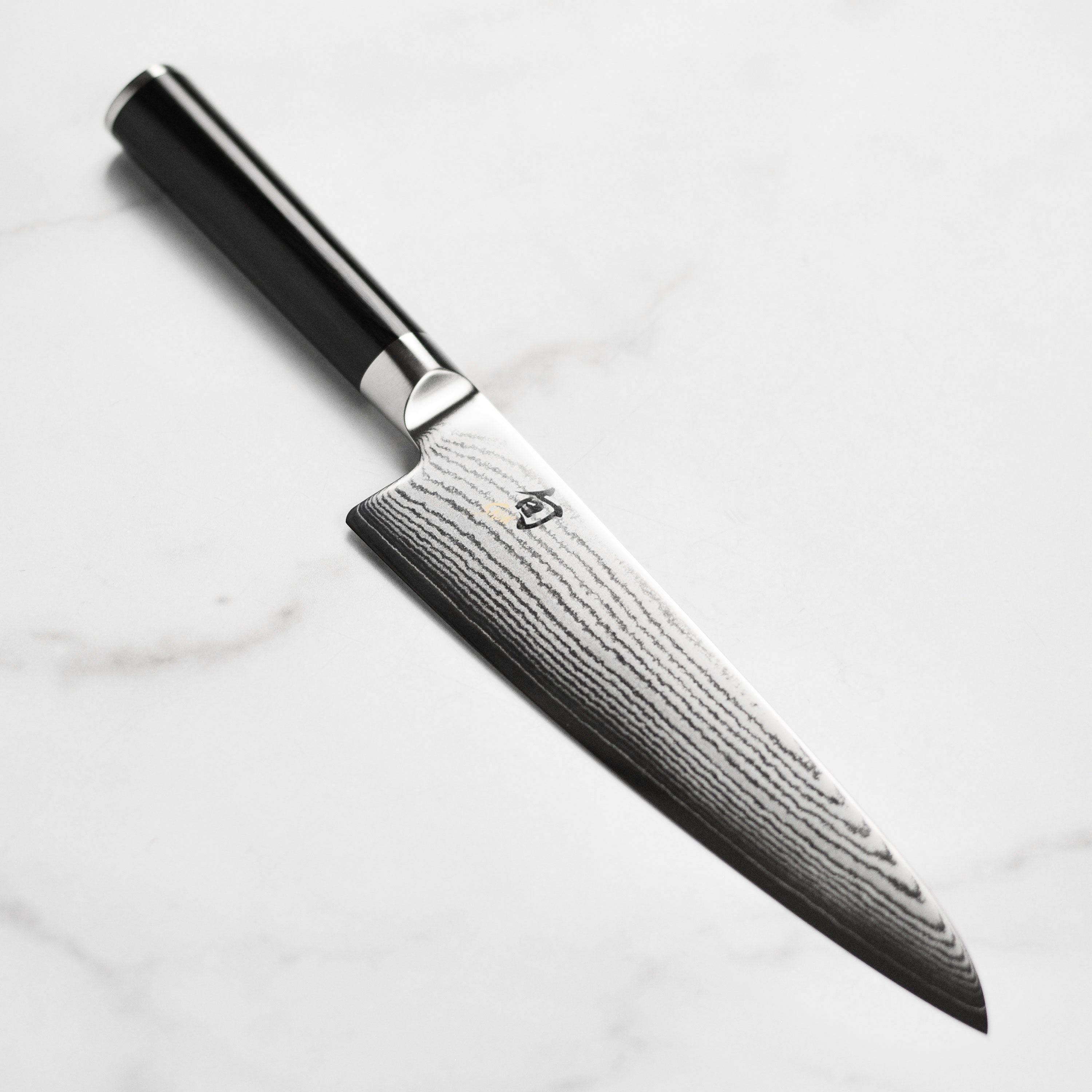 Shun Classic 7 inch Damascus chef's knife showcasing the elegant design and sharp blade.
