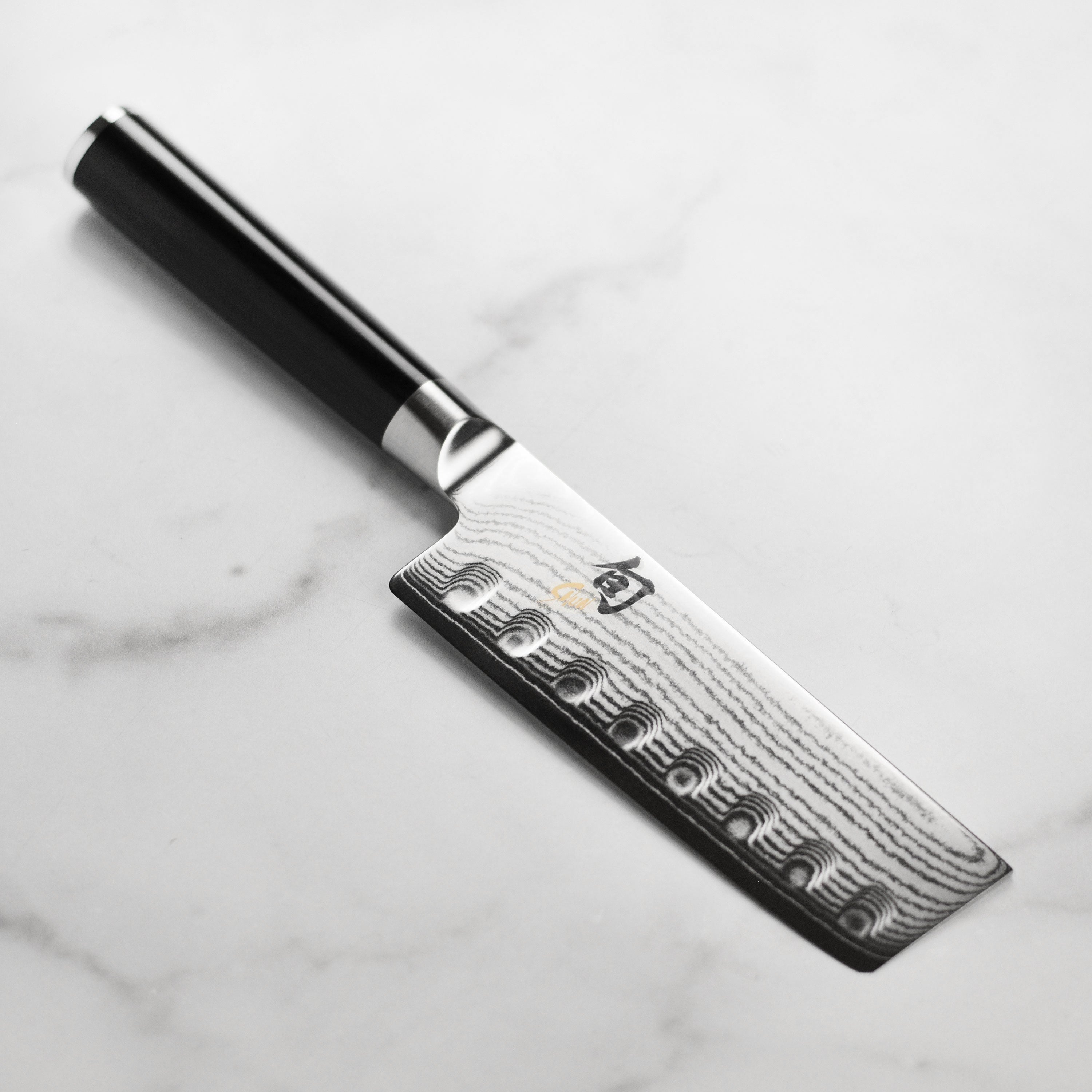 Close-up view of the VG-MAX Damascus Nakiri knife showcasing its 34 layers of stainless steel.
