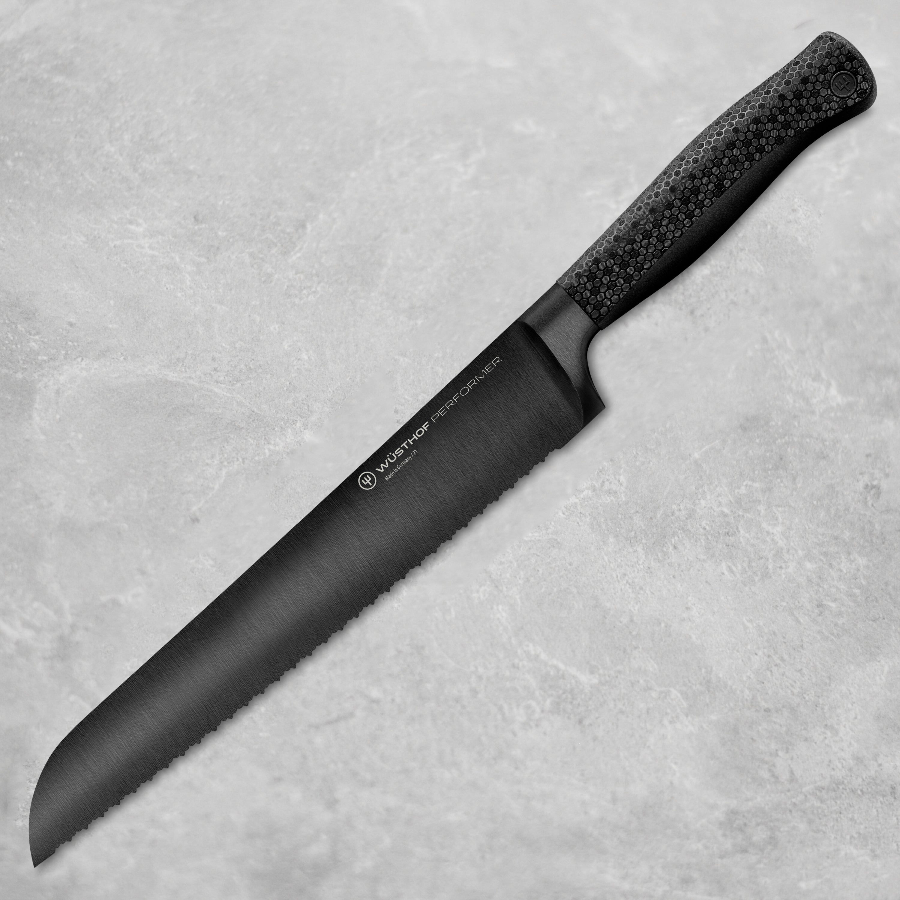Wusthof Performer 9-inch double serrated bread knife slicing crusty bread in a professional kitchen