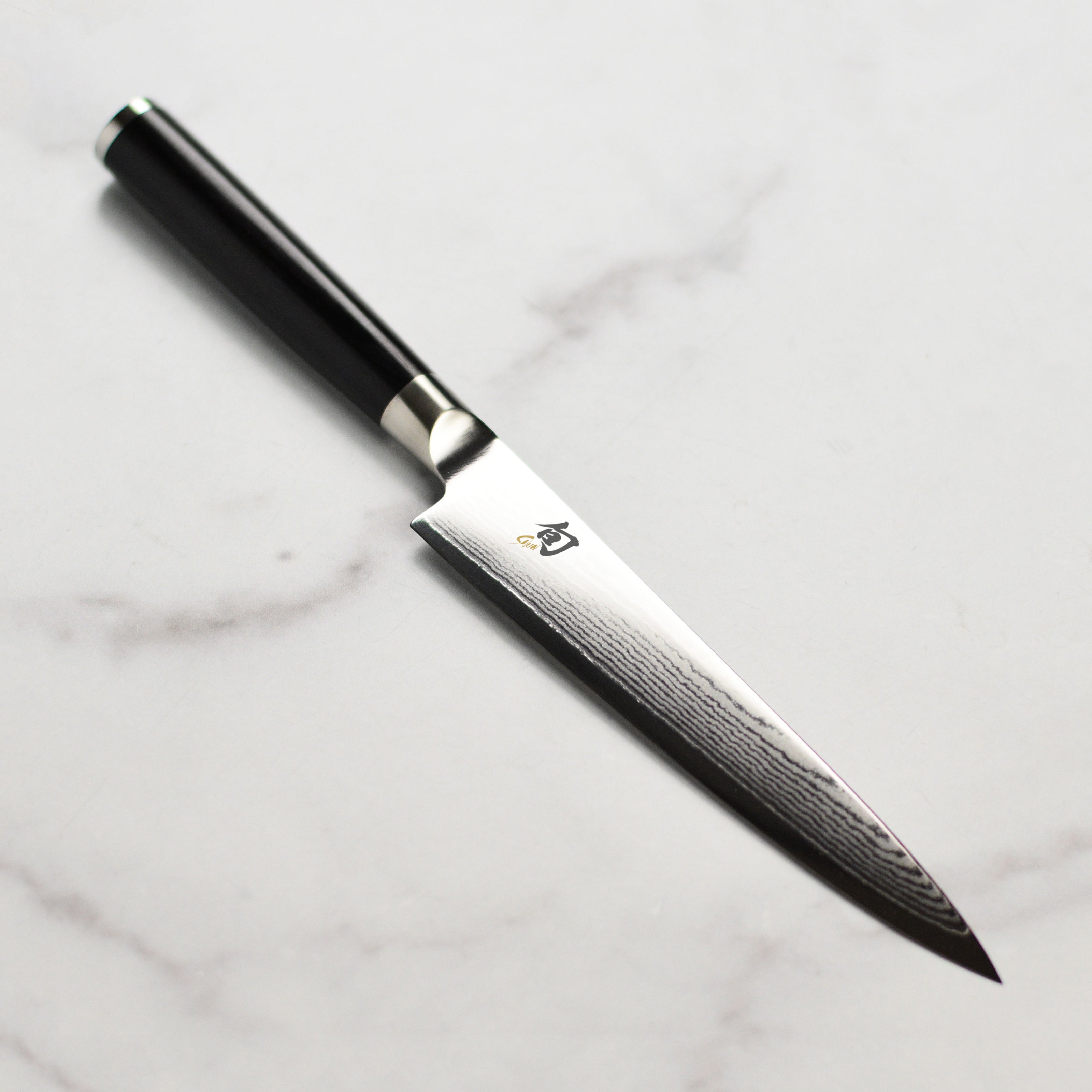 Shun Classic 6-inch utility knife showcasing its sharp blade and elegant design for kitchen tasks.