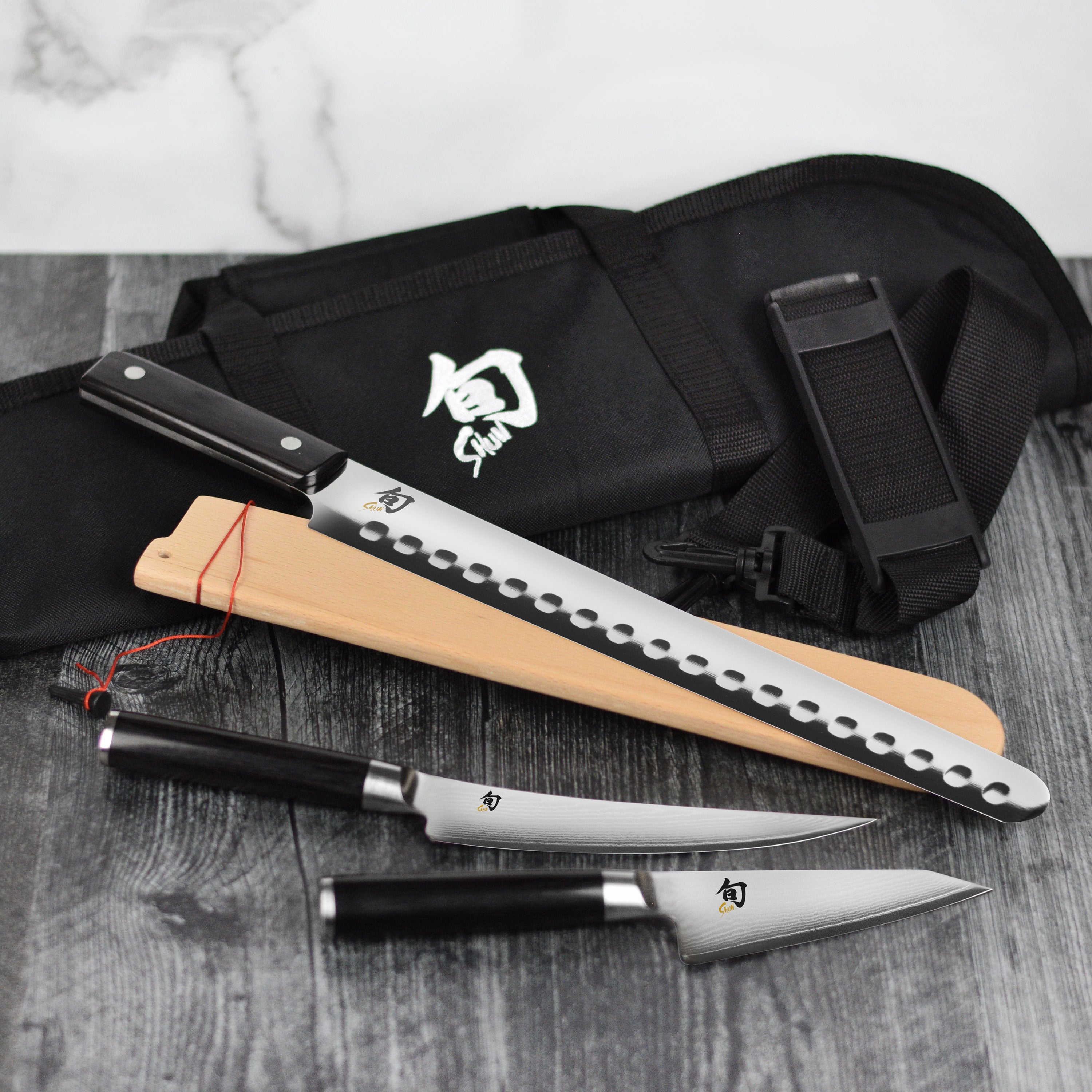 Close-up of Japanese BBQ knives with Damascus steel blades and black handles for grilling