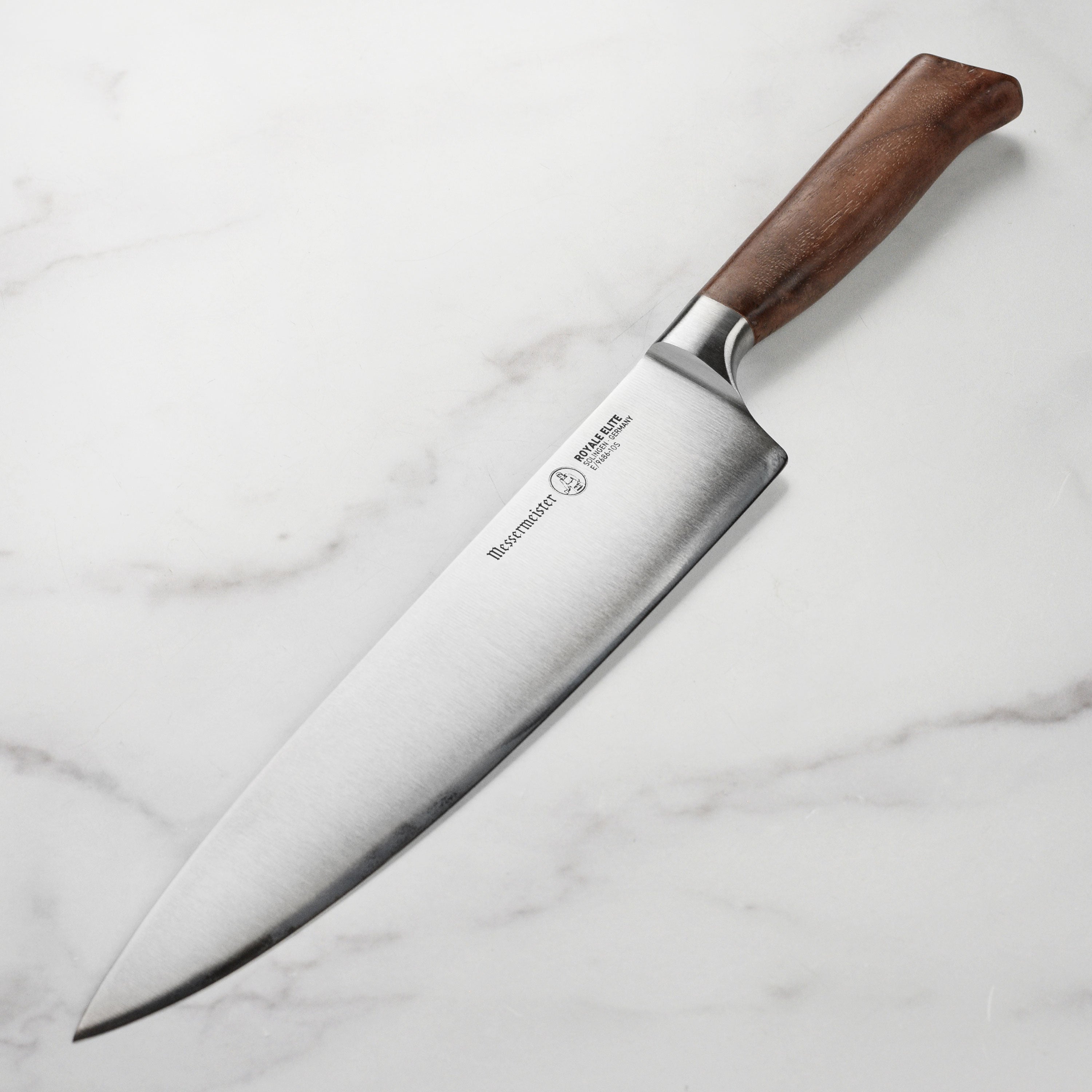 Top-down view of the 10-inch Messermeister knife showing its polished steel blade and walnut burl handle