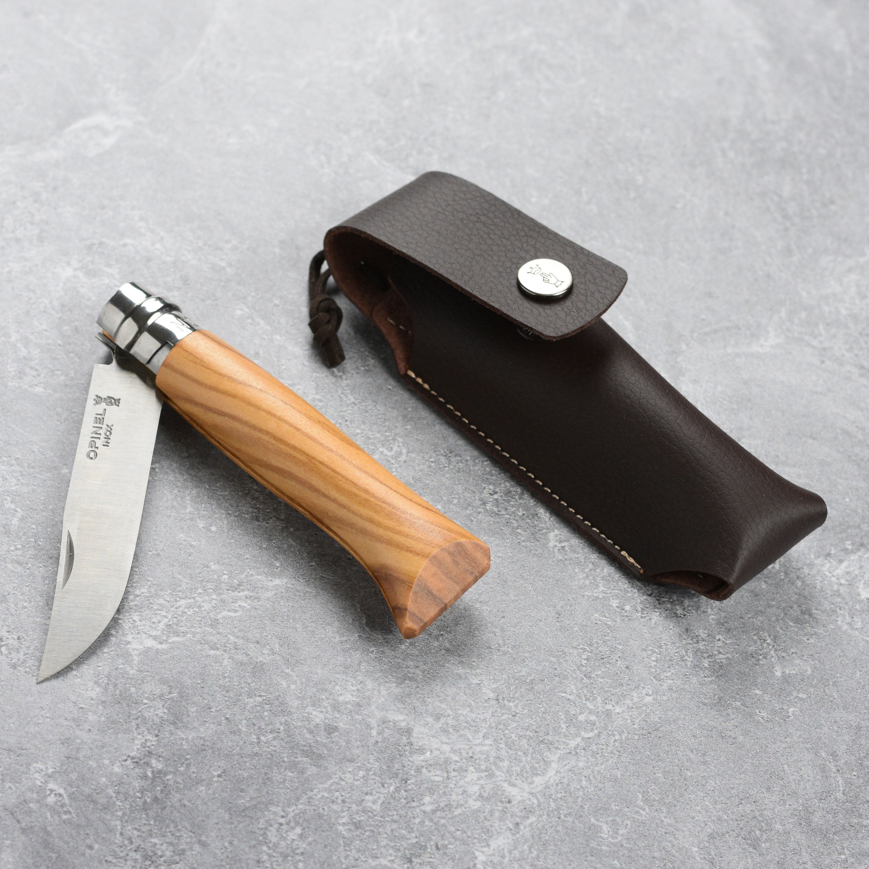 Close-up of Opinel No. 8 folding knife showing polished olive wood handle and stainless steel blade