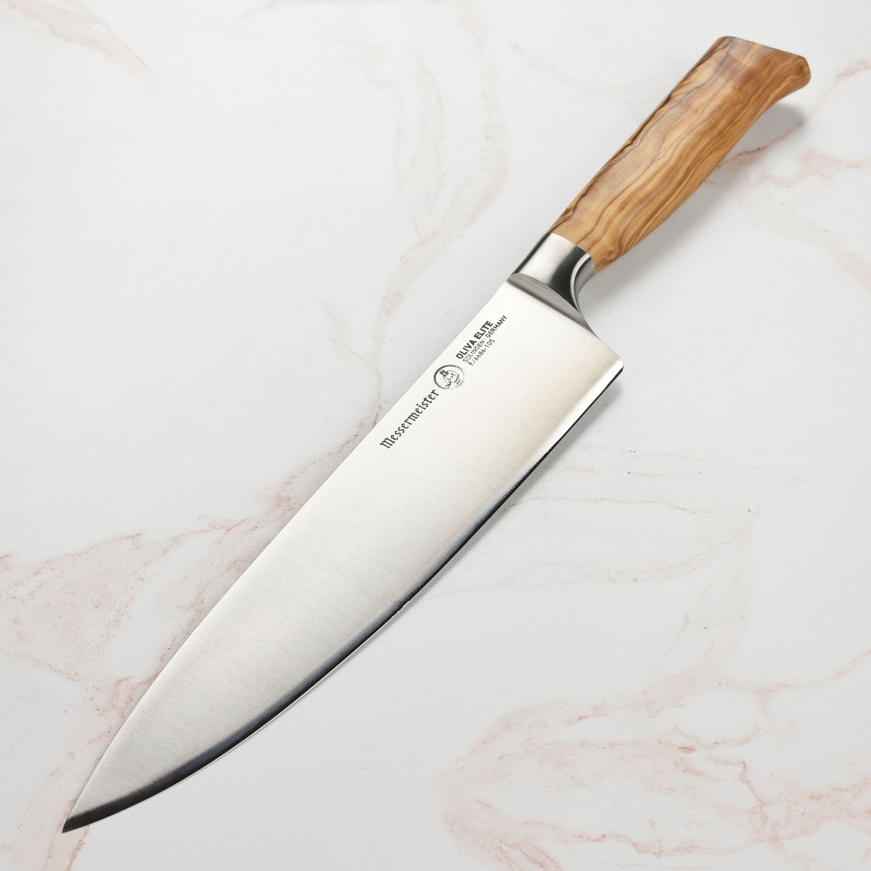 Close-up of the 10-inch chef's knife showcasing the German steel blade and olive wood handle.
