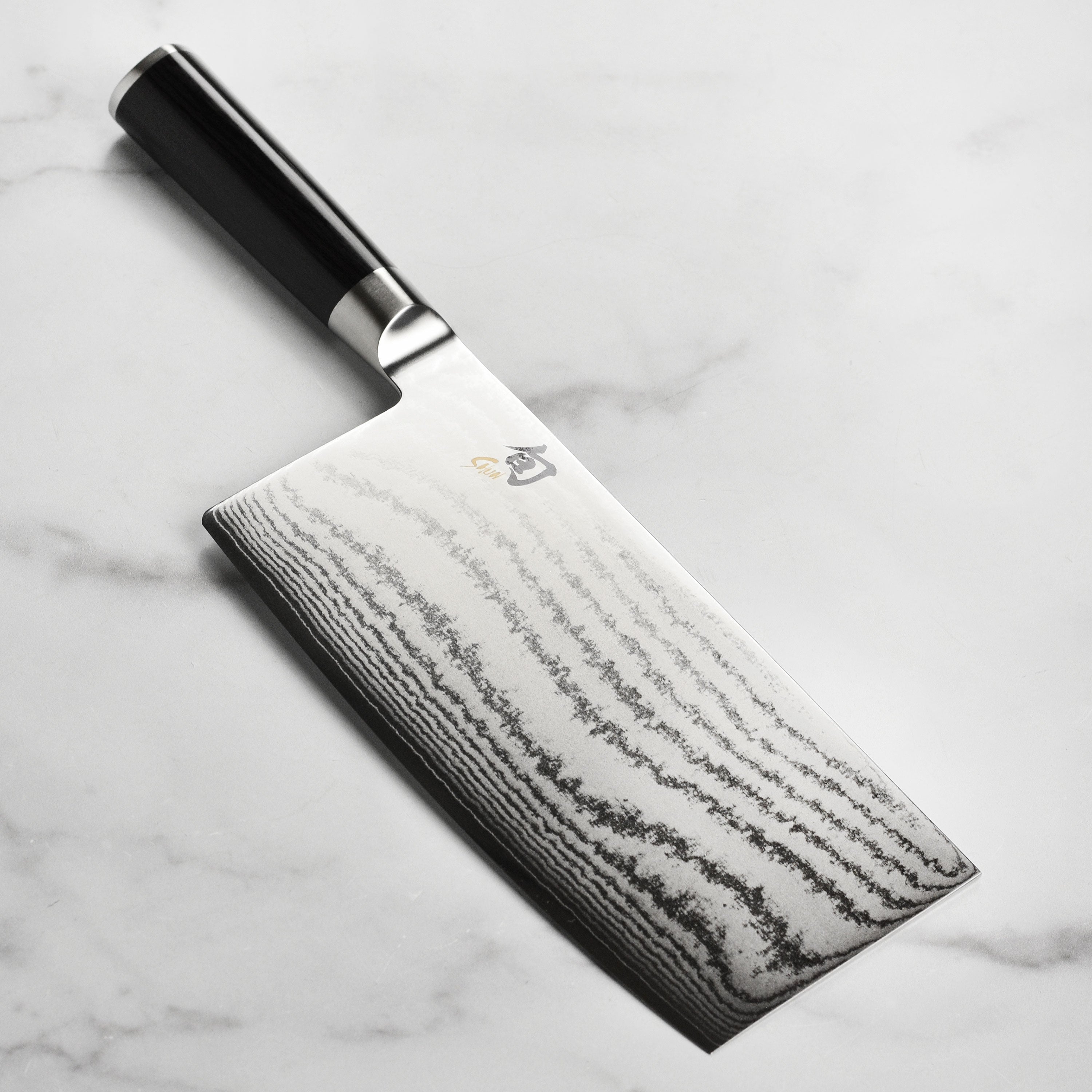 Handcrafted Japanese vegetable cleaver with Damascus steel layers and ebony handle, perfect for precise chopping.