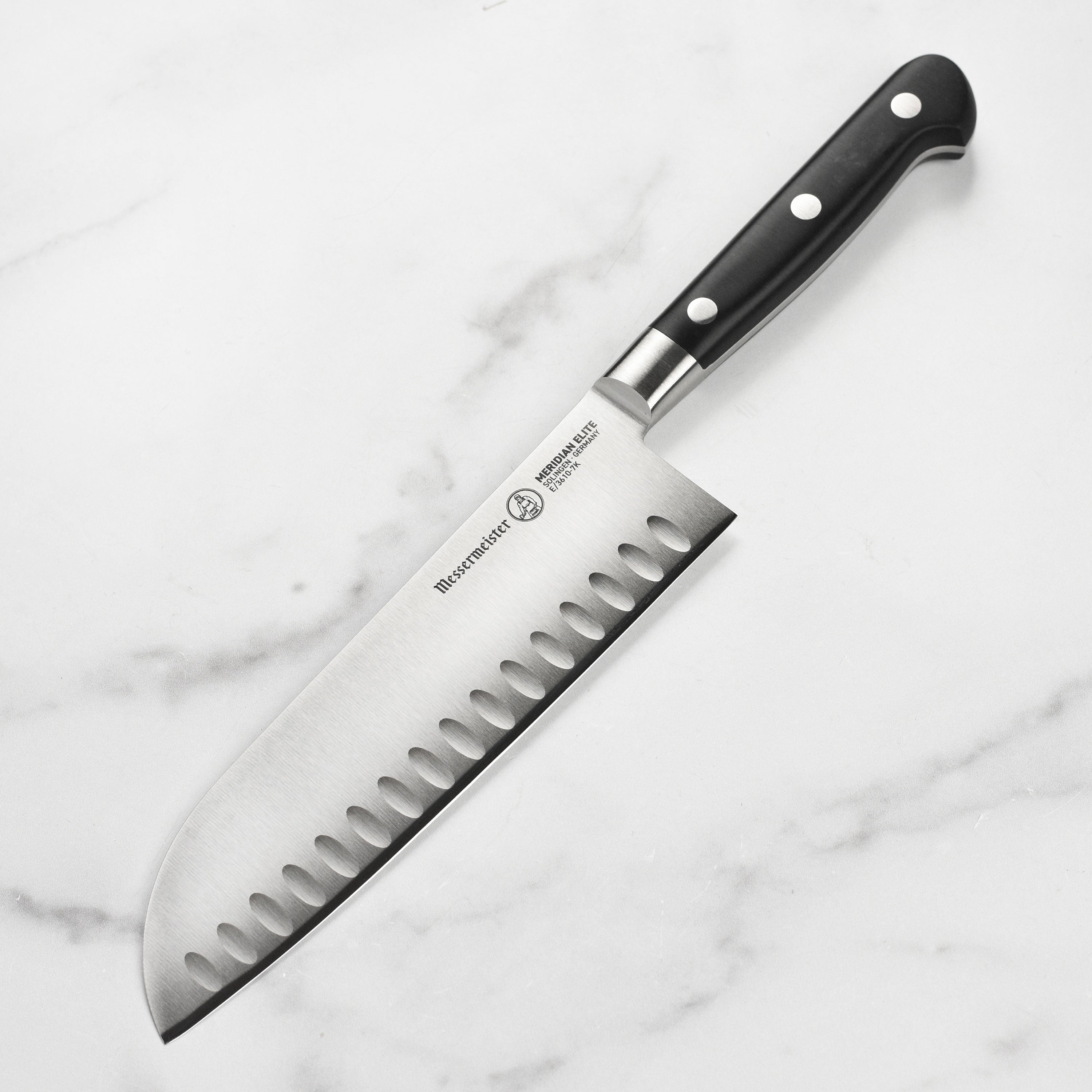 Top view of the Messermeister Meridian Elite 7-inch hollow edge Santoku knife highlighting its sharp blade and ergonomic handle