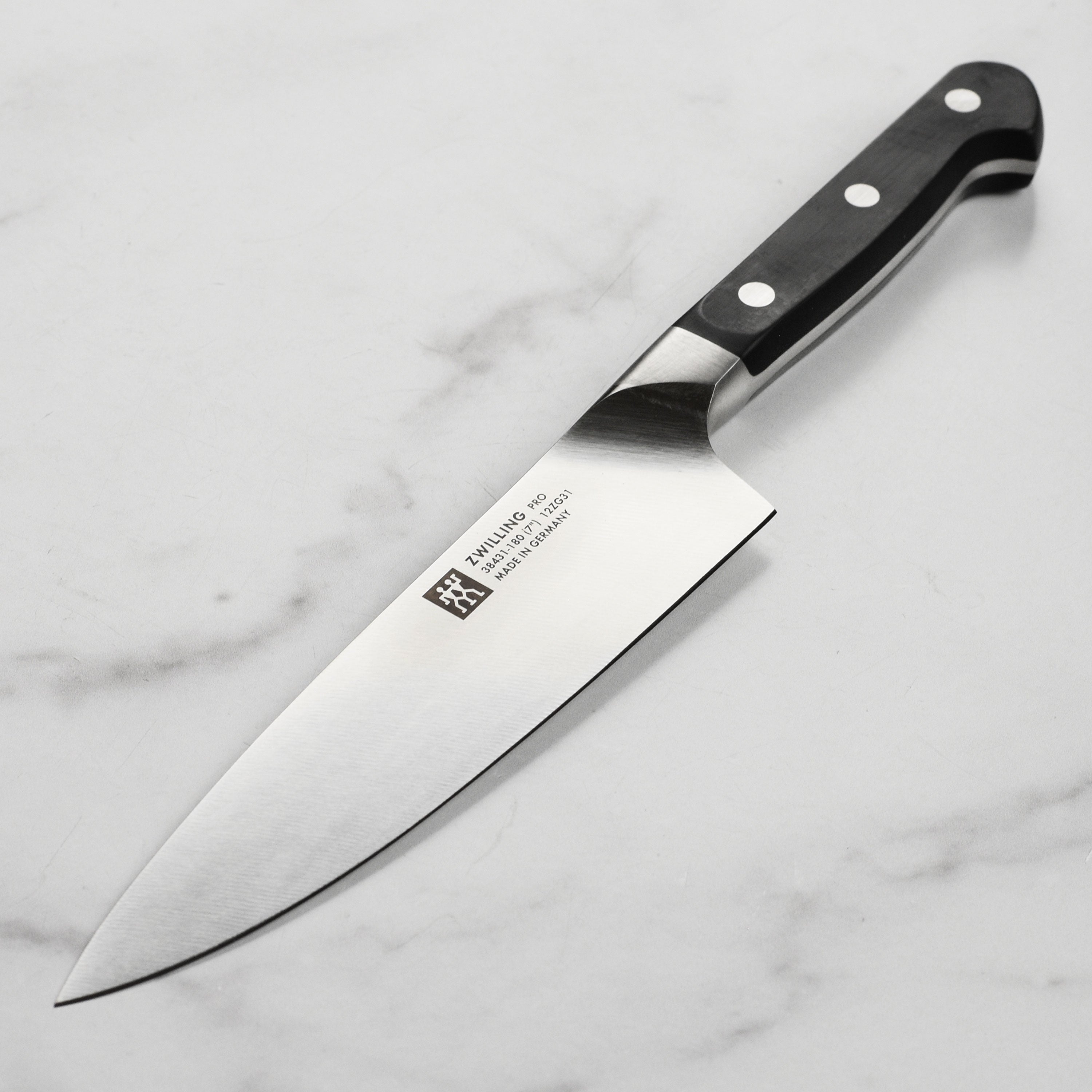 Close-up of the slim kitchen knife blade showing the German high carbon steel finish