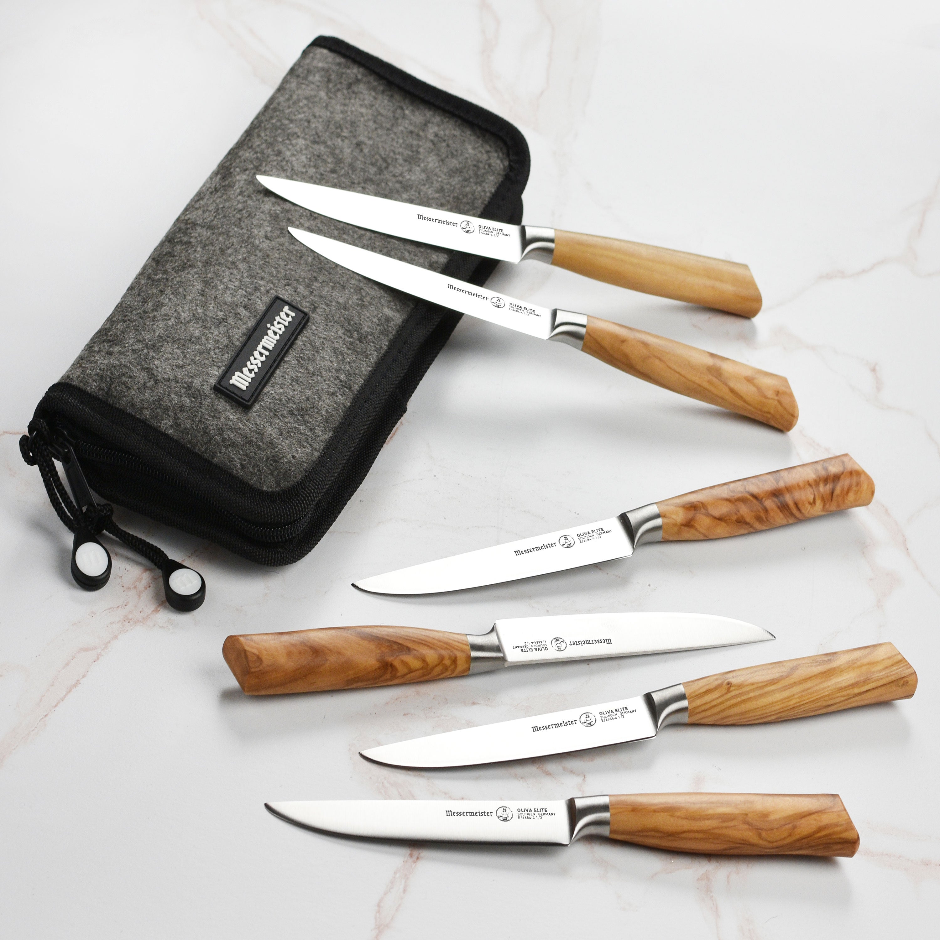 Close-up of forged steak knife blade showing polished edge and olive wood handle