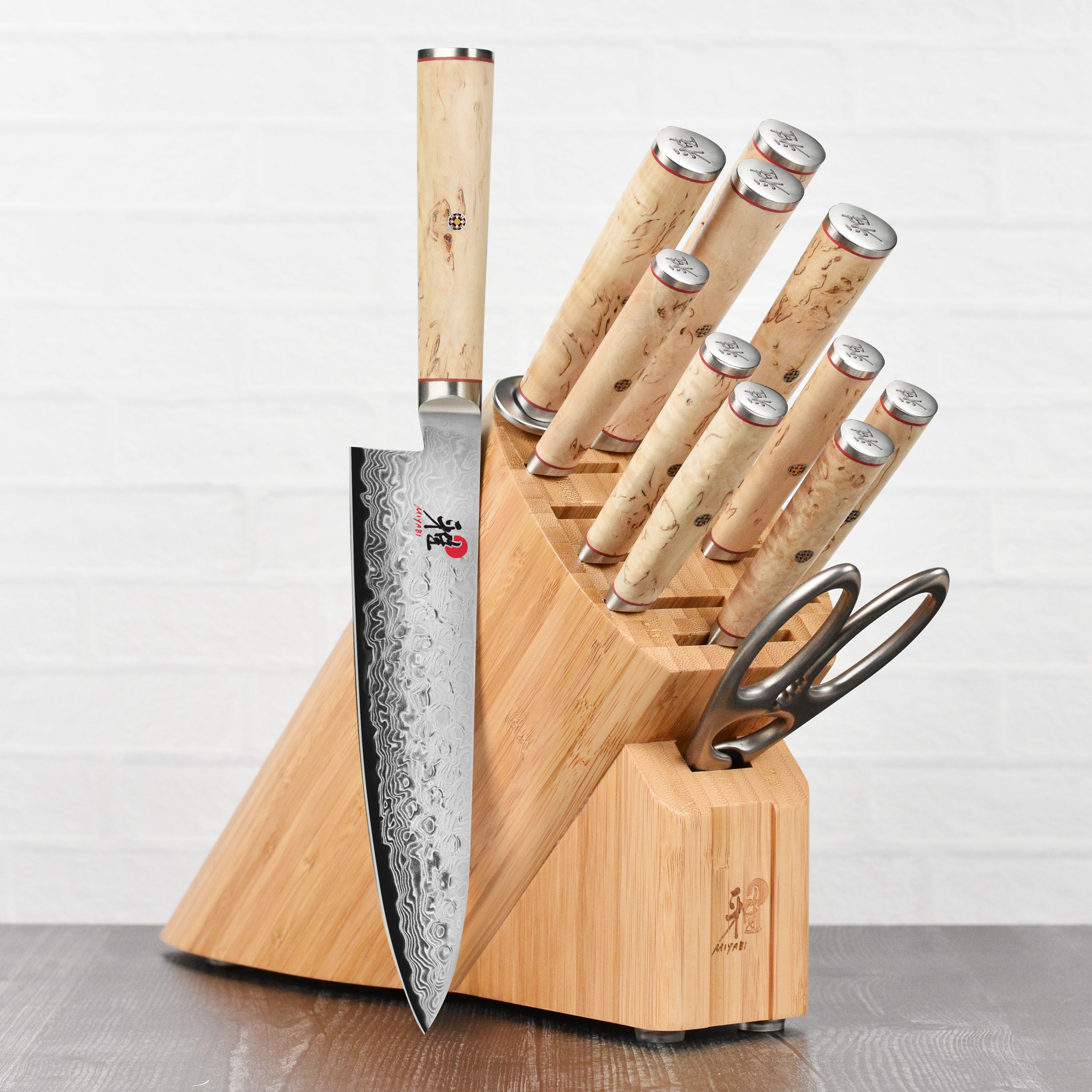 Miyabi Birchwood SG2 13-piece knife set with Damascus steel blades displayed on a wooden block