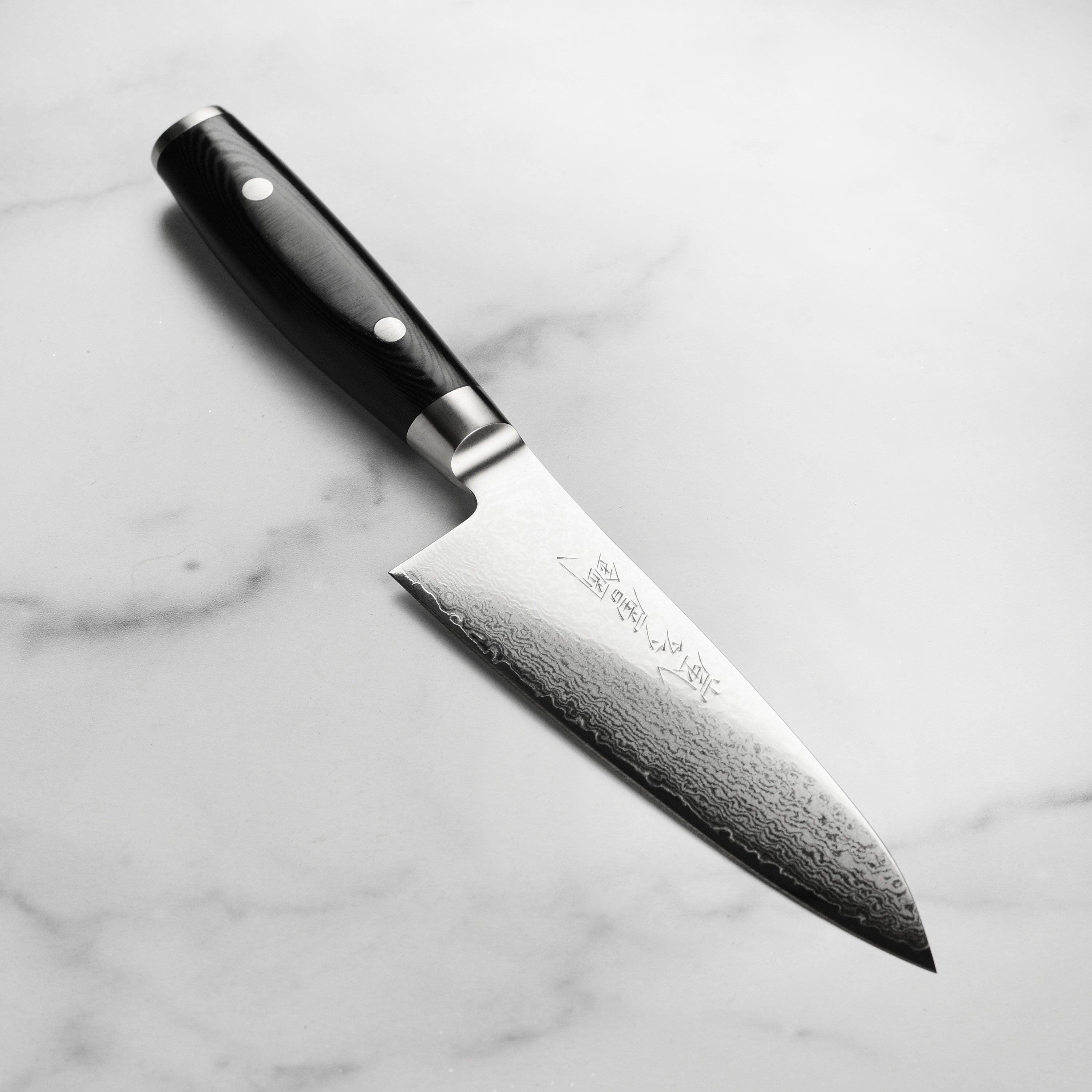 Yaxell Ran Plus Damascus chef's knife with layered steel pattern and ergonomic handle