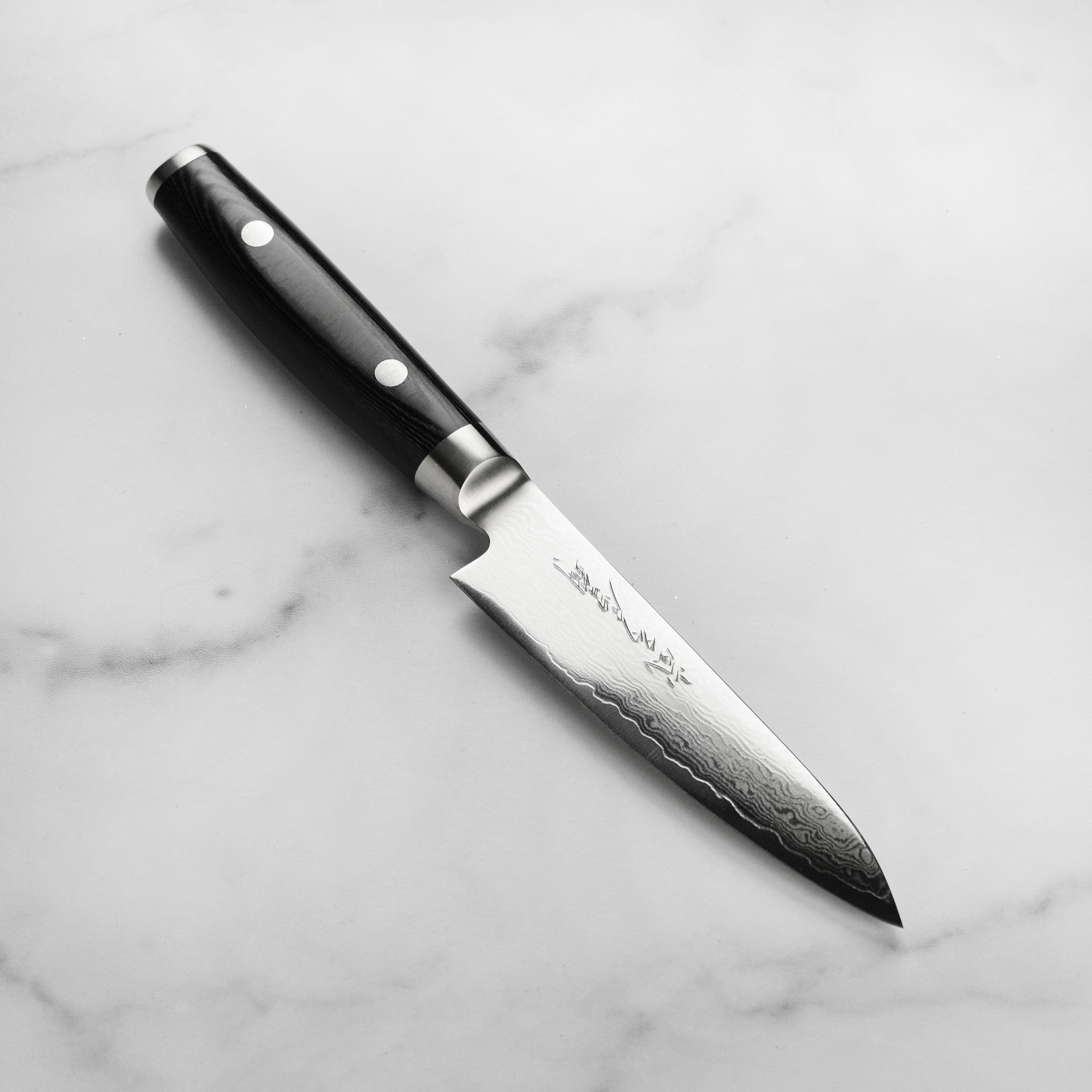 Yaxell Ran Plus petty knife blade with Damascus steel pattern and engraved kanji
