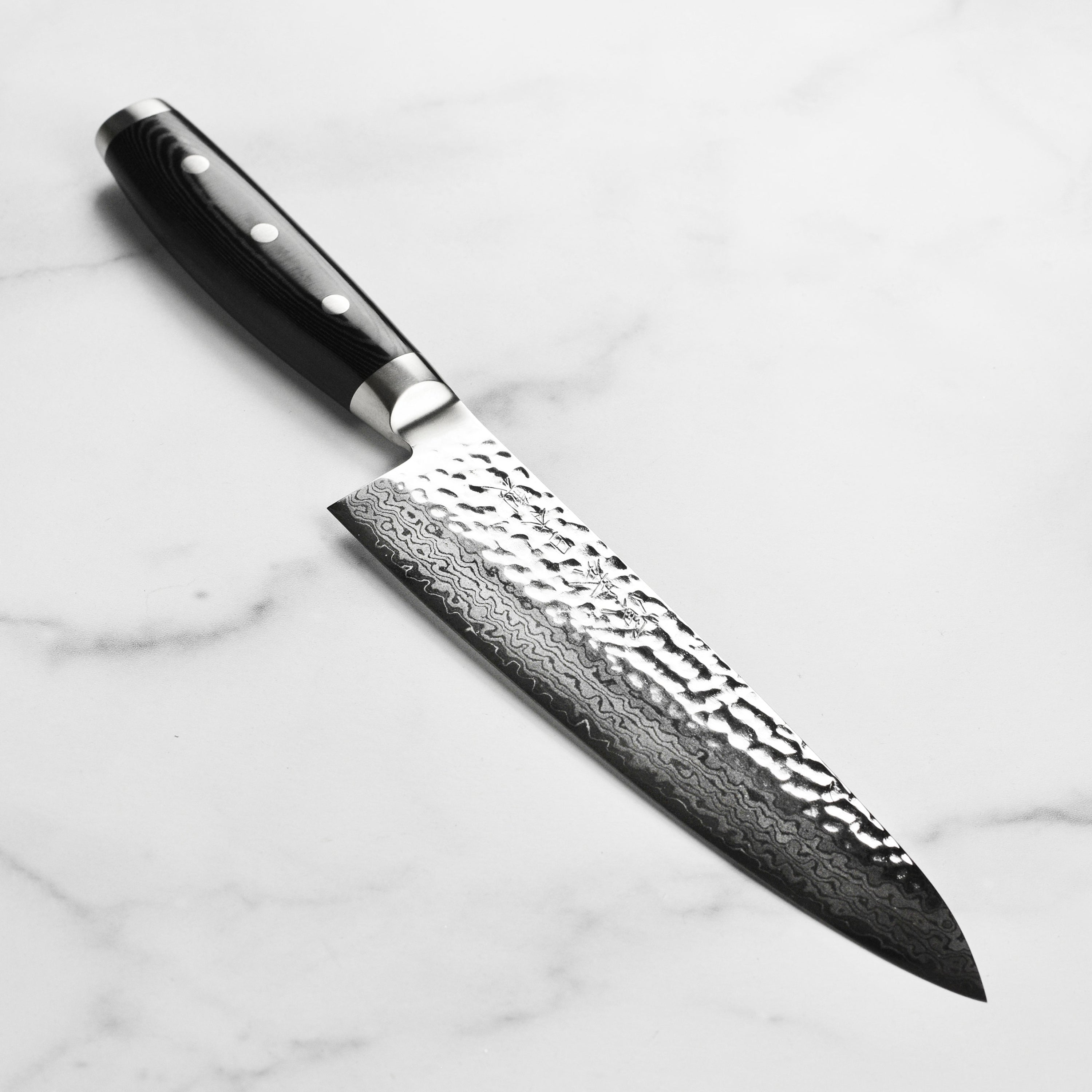 Close-up of the Enso HD Damascus 8-inch chef's knife showing the hammered tsuchime finish and layered steel blade