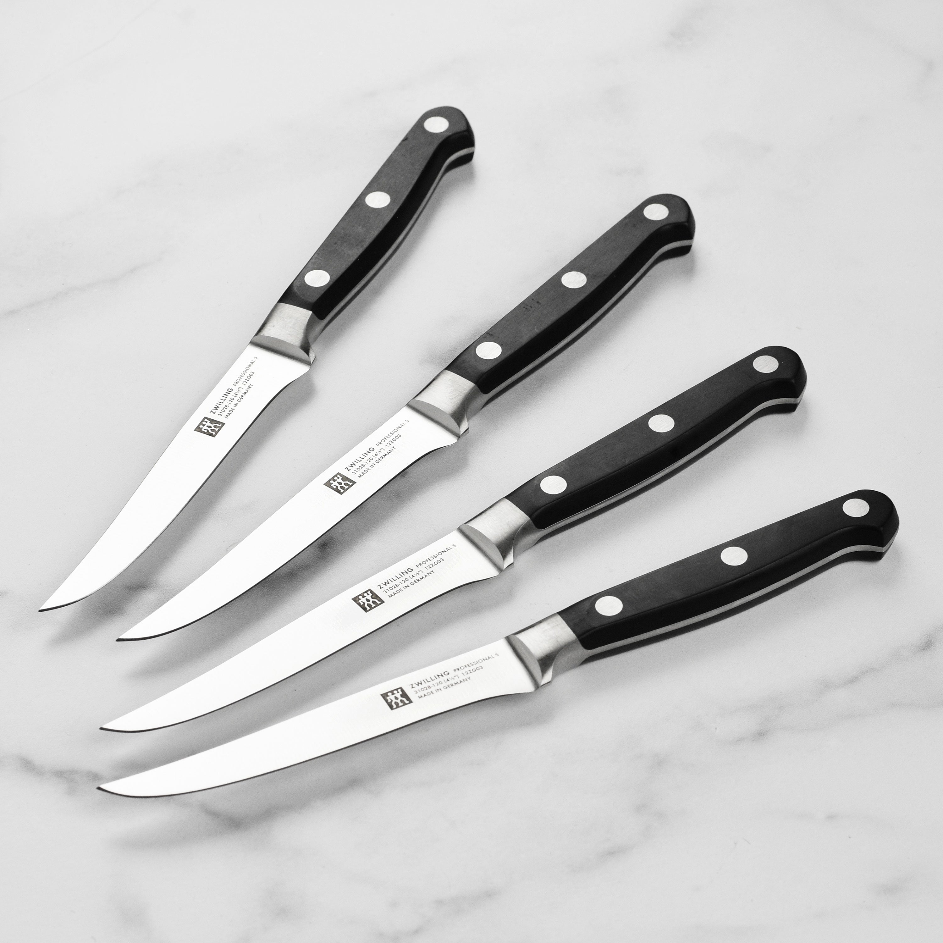 Close-up of the Precision Forged German Steak Knife Set showcasing the sharp blades and ergonomic handles.