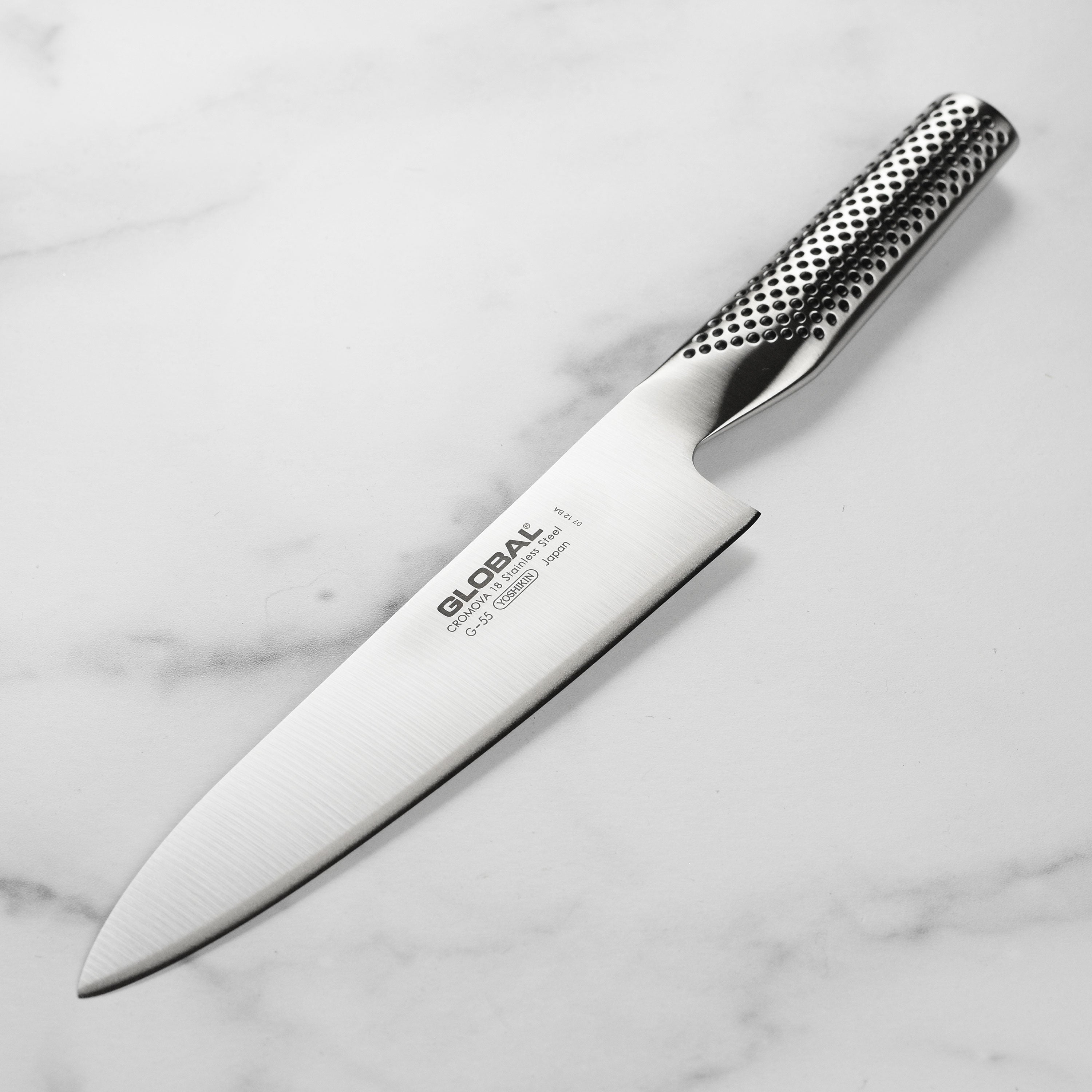 Close-up of Global Ergonomic 7 Inch Chef's Knife showing the razor-sharp edge and ergonomic handle.