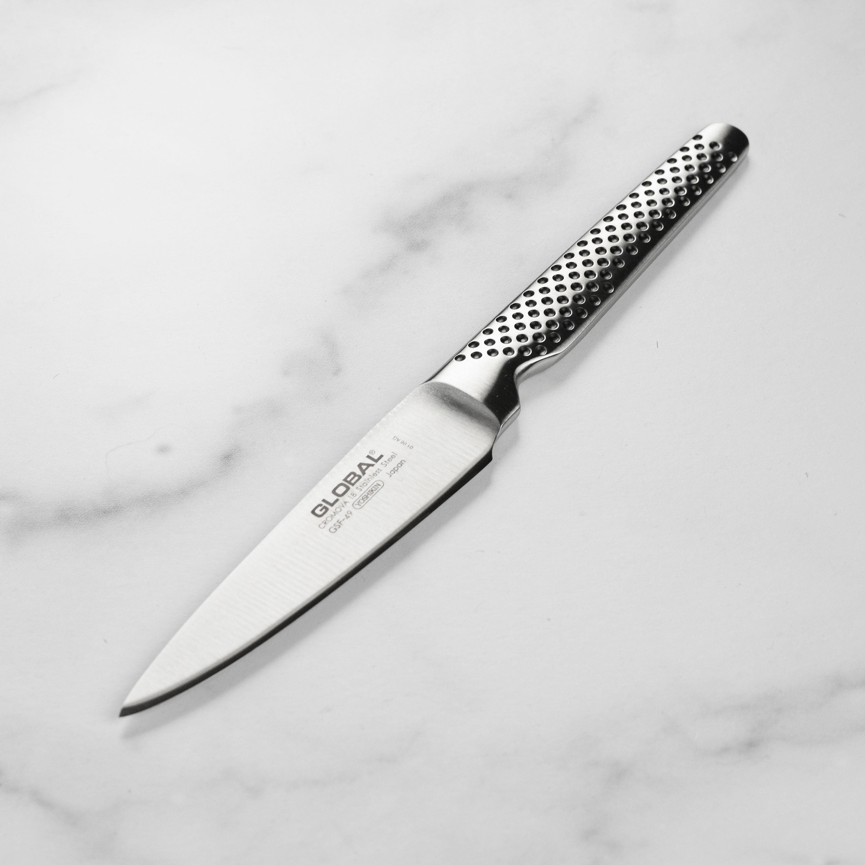 Close-up of SharpCraft utility knife showing dimple-pattern stainless steel handle and sharp Japanese blade